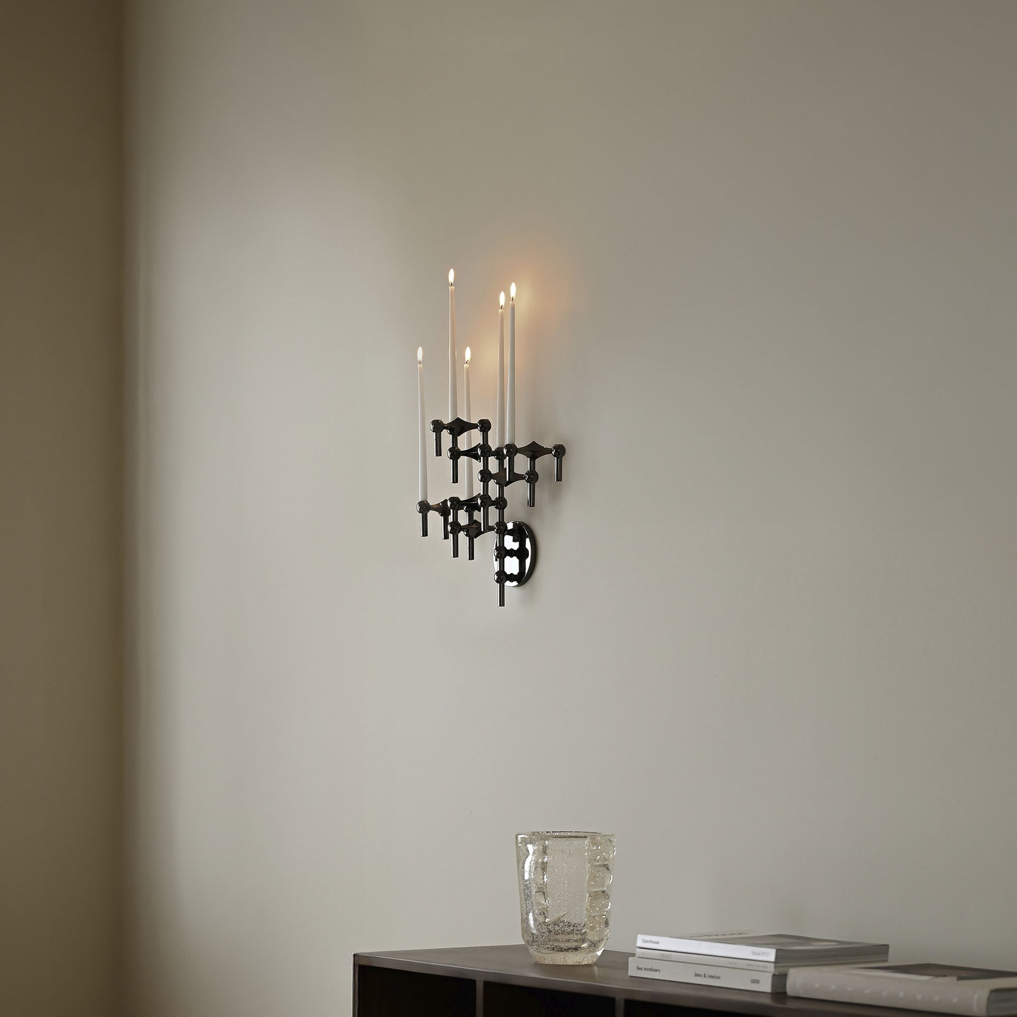 Stoff（ストッフ）は、デンマーク発のデザインブランドで、1960年代の名作「Stoff Nagel（ストッフ・ナゲル）」キャンドルホルダーの復刻から始まりました。建築家Werner Stoff（ヴェルナー・ストッフ）と、ドイツのHans Nagel（ハンス・ナゲル）によって生み出されたこのモジュール式キャンドルホルダーは、彫刻のような幾何学美と、自由な組み合わせによる創造性を兼ね備えたインテリアアートです。現在のStoffは、オリジナルの精神を受け継ぎながら、現代のライフスタイルに合う素材や仕上げを追加し、キャンドルホルダーだけでなくフラワーベースやボウル、ウォールハンガーなど洗練されたアイテムを展開。ミッドセンチュリーや北欧インテリアに調和し、空間に立体感と静謐な存在感を与えます。構築と装飾の境界を超えたStoffの作品は、機能性と造形美が共存する稀有なプロダクトです。