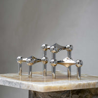 Stoff（ストッフ）は、デンマーク発のデザインブランドで、1960年代の名作「Stoff Nagel（ストッフ・ナゲル）」キャンドルホルダーの復刻から始まりました。建築家Werner Stoff（ヴェルナー・ストッフ）と、ドイツのHans Nagel（ハンス・ナゲル）によって生み出されたこのモジュール式キャンドルホルダーは、彫刻のような幾何学美と、自由な組み合わせによる創造性を兼ね備えたインテリアアートです。現在のStoffは、オリジナルの精神を受け継ぎながら、現代のライフスタイルに合う素材や仕上げを追加し、キャンドルホルダーだけでなくフラワーベースやボウル、ウォールハンガーなど洗練されたアイテムを展開。ミッドセンチュリーや北欧インテリアに調和し、空間に立体感と静謐な存在感を与えます。構築と装飾の境界を超えたStoffの作品は、機能性と造形美が共存する稀有なプロダクトです。