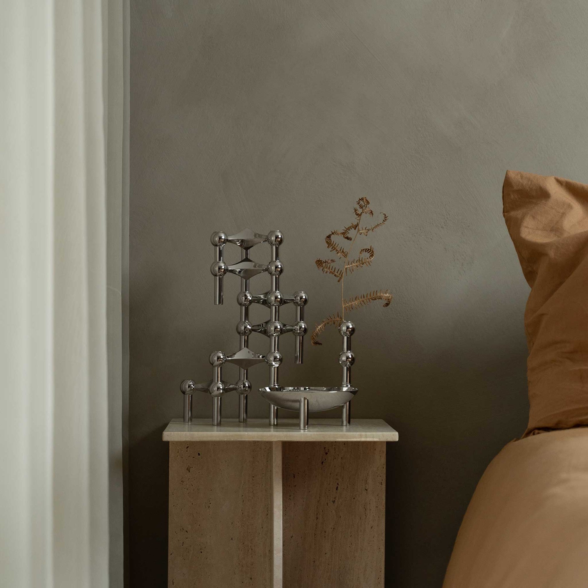 Stoff（ストッフ）は、デンマーク発のデザインブランドで、1960年代の名作「Stoff Nagel（ストッフ・ナゲル）」キャンドルホルダーの復刻から始まりました。建築家Werner Stoff（ヴェルナー・ストッフ）と、ドイツのHans Nagel（ハンス・ナゲル）によって生み出されたこのモジュール式キャンドルホルダーは、彫刻のような幾何学美と、自由な組み合わせによる創造性を兼ね備えたインテリアアートです。現在のStoffは、オリジナルの精神を受け継ぎながら、現代のライフスタイルに合う素材や仕上げを追加し、キャンドルホルダーだけでなくフラワーベースやボウル、ウォールハンガーなど洗練されたアイテムを展開。ミッドセンチュリーや北欧インテリアに調和し、空間に立体感と静謐な存在感を与えます。構築と装飾の境界を超えたStoffの作品は、機能性と造形美が共存する稀有なプロダクトです。