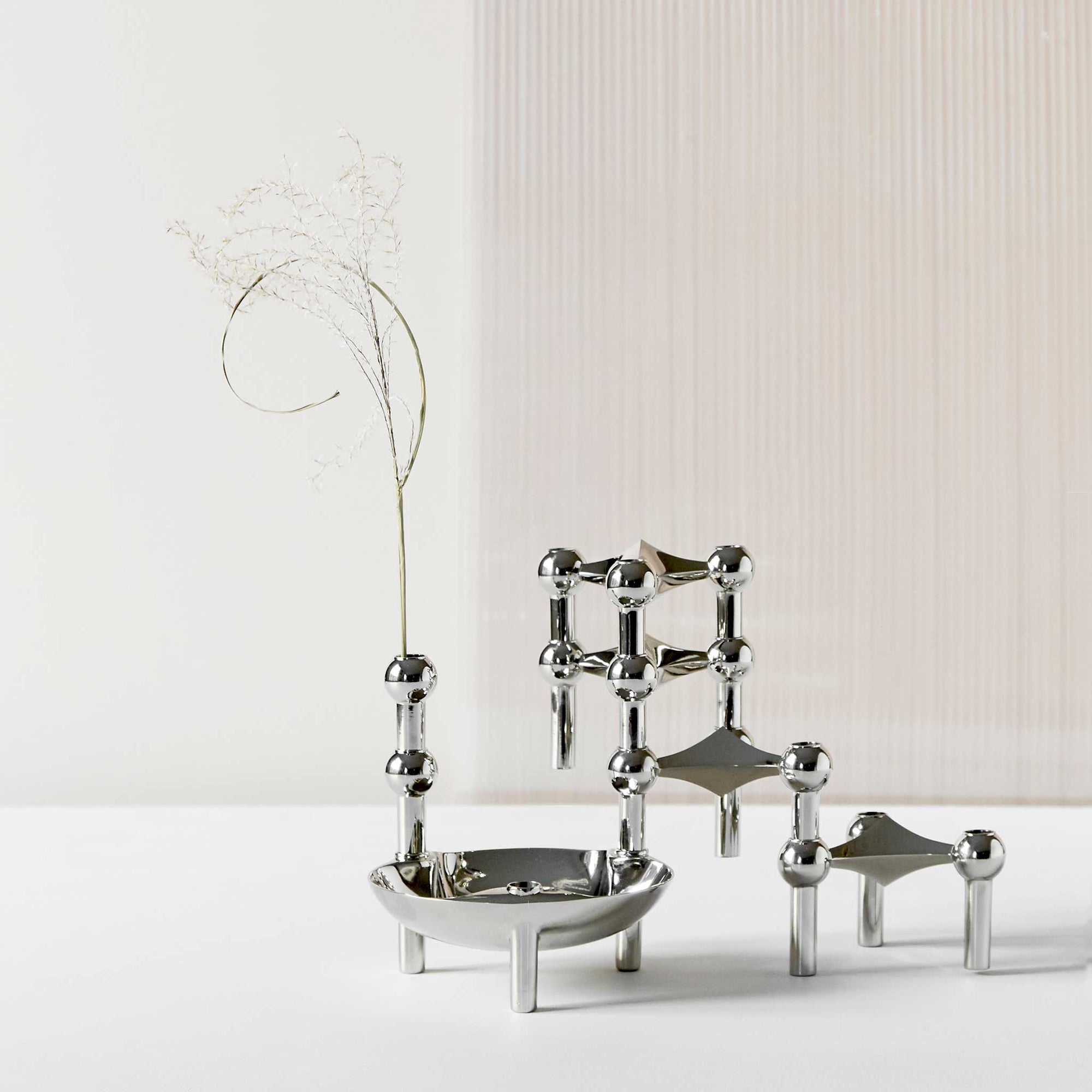 Stoff（ストッフ）は、デンマーク発のデザインブランドで、1960年代の名作「Stoff Nagel（ストッフ・ナゲル）」キャンドルホルダーの復刻から始まりました。建築家Werner Stoff（ヴェルナー・ストッフ）と、ドイツのHans Nagel（ハンス・ナゲル）によって生み出されたこのモジュール式キャンドルホルダーは、彫刻のような幾何学美と、自由な組み合わせによる創造性を兼ね備えたインテリアアートです。現在のStoffは、オリジナルの精神を受け継ぎながら、現代のライフスタイルに合う素材や仕上げを追加し、キャンドルホルダーだけでなくフラワーベースやボウル、ウォールハンガーなど洗練されたアイテムを展開。ミッドセンチュリーや北欧インテリアに調和し、空間に立体感と静謐な存在感を与えます。構築と装飾の境界を超えたStoffの作品は、機能性と造形美が共存する稀有なプロダクトです。