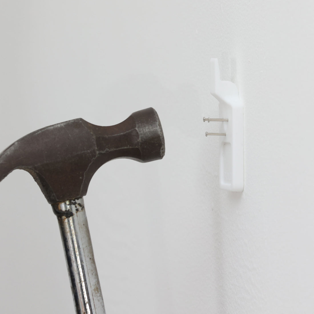 北欧スウェーデンのブランド「BOLD」が開発した、革新的なピクチャーフックです。従来の金属製フックとは異なり、軽量で耐久性の高いプラスチック製を採用。壁へのダメージを最小限に抑えながら、アートや額縁を美しく、確実に掛けることができます。取り付けは驚くほど簡単で、ドリルやアンカーを使わず、付属の細いスチールピンをハンマーで打ち込むだけ。数秒で設置でき、外した跡もほとんど目立ちません。一般的な石こうボードや木壁はもちろん、コンクリート壁にも対応します。素材には柔軟性と高い衝撃吸収性を兼ね備えた熱可塑性プラスチックを採用。フレームをしっかり支えながらも、壁面や釘への負担を軽減します。北欧らしい機能美と合理性を追求したBOLDのピクチャーフックは、壁にアートを飾るという日常の動作を、より簡単でスマートな体験へと変えてくれます。