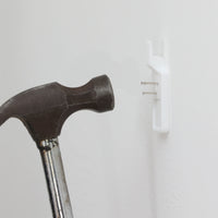 北欧スウェーデンのブランド「BOLD」が開発した、革新的なピクチャーフックです。従来の金属製フックとは異なり、軽量で耐久性の高いプラスチック製を採用。壁へのダメージを最小限に抑えながら、アートや額縁を美しく、確実に掛けることができます。取り付けは驚くほど簡単で、ドリルやアンカーを使わず、付属の細いスチールピンをハンマーで打ち込むだけ。数秒で設置でき、外した跡もほとんど目立ちません。一般的な石こうボードや木壁はもちろん、コンクリート壁にも対応します。素材には柔軟性と高い衝撃吸収性を兼ね備えた熱可塑性プラスチックを採用。フレームをしっかり支えながらも、壁面や釘への負担を軽減します。北欧らしい機能美と合理性を追求したBOLDのピクチャーフックは、壁にアートを飾るという日常の動作を、より簡単でスマートな体験へと変えてくれます。