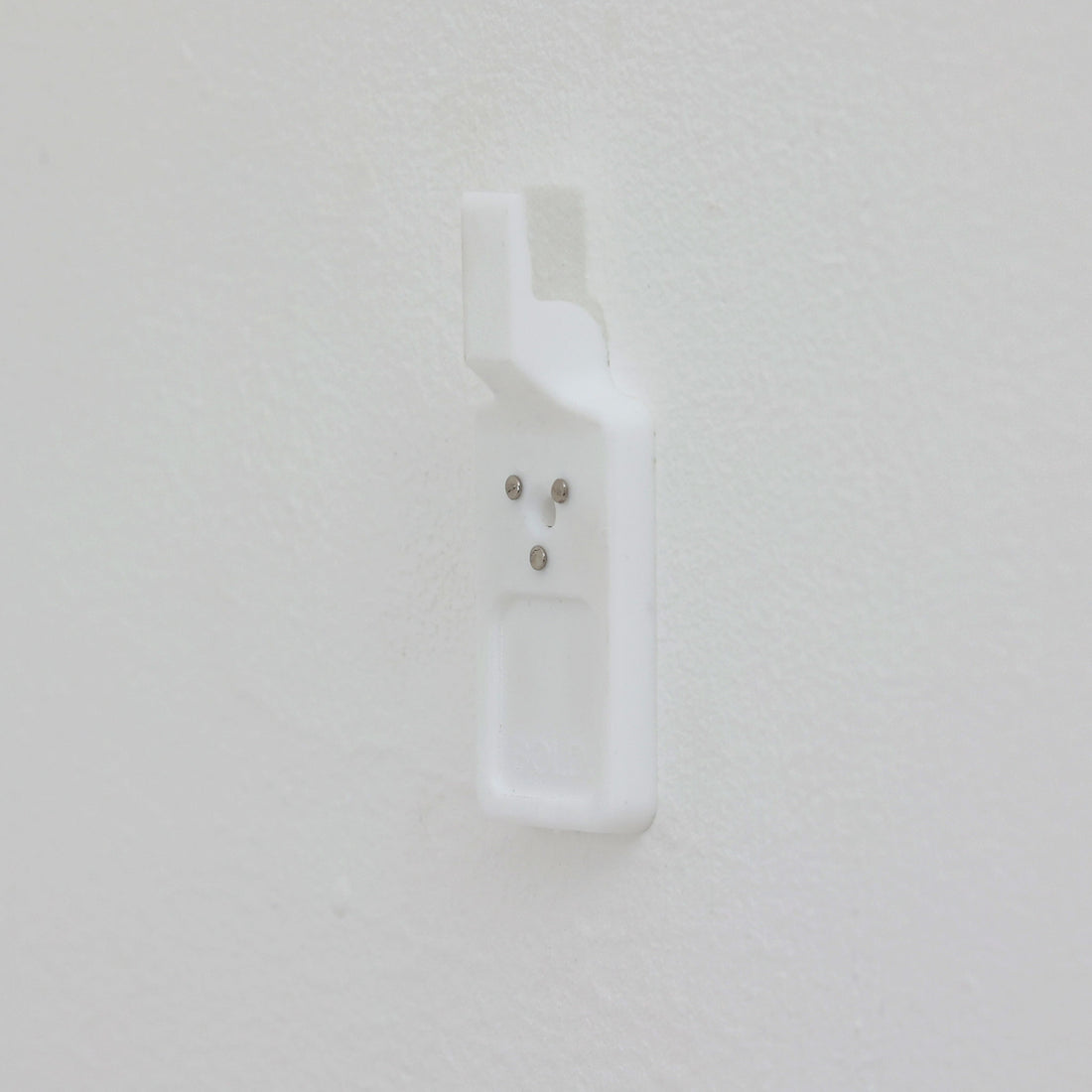 北欧スウェーデンのブランド「BOLD」が開発した、革新的なピクチャーフックです。従来の金属製フックとは異なり、軽量で耐久性の高いプラスチック製を採用。壁へのダメージを最小限に抑えながら、アートや額縁を美しく、確実に掛けることができます。取り付けは驚くほど簡単で、ドリルやアンカーを使わず、付属の細いスチールピンをハンマーで打ち込むだけ。数秒で設置でき、外した跡もほとんど目立ちません。一般的な石こうボードや木壁はもちろん、コンクリート壁にも対応します。素材には柔軟性と高い衝撃吸収性を兼ね備えた熱可塑性プラスチックを採用。フレームをしっかり支えながらも、壁面や釘への負担を軽減します。北欧らしい機能美と合理性を追求したBOLDのピクチャーフックは、壁にアートを飾るという日常の動作を、より簡単でスマートな体験へと変えてくれます。