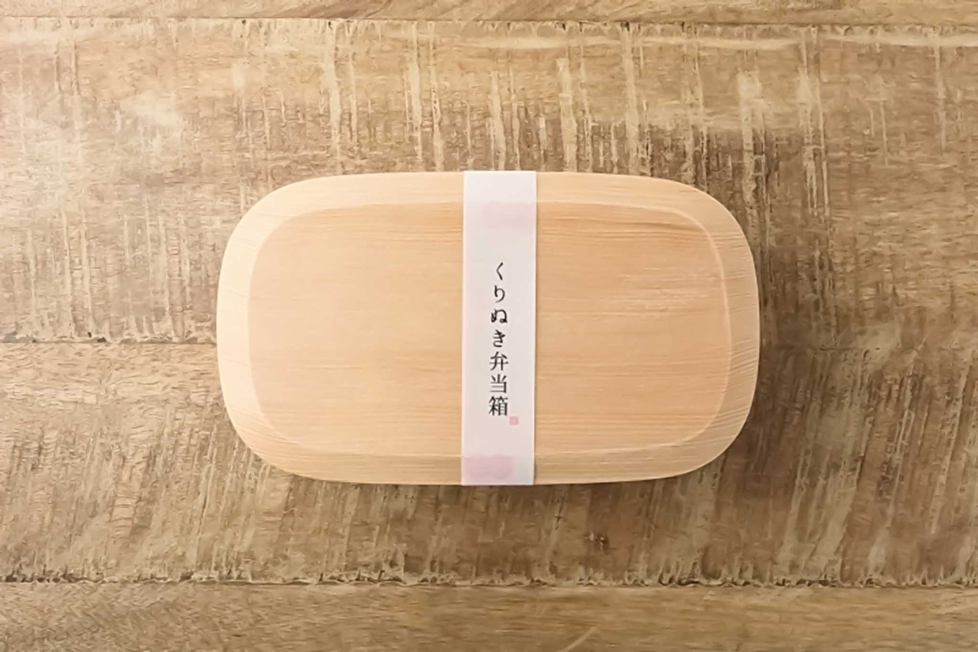 天然木をくりぬいて仕上げた、上品な表情が特長の弁当箱です。木目の美しさと しっかりとした板厚の存在感を楽しめます。なめらかな曲線は手に優しく、天然木の風合いがお料理を格別に引き立てます。おもてなしや、行楽・お花見のお弁当、和菓子を入れても可愛らしいですね。