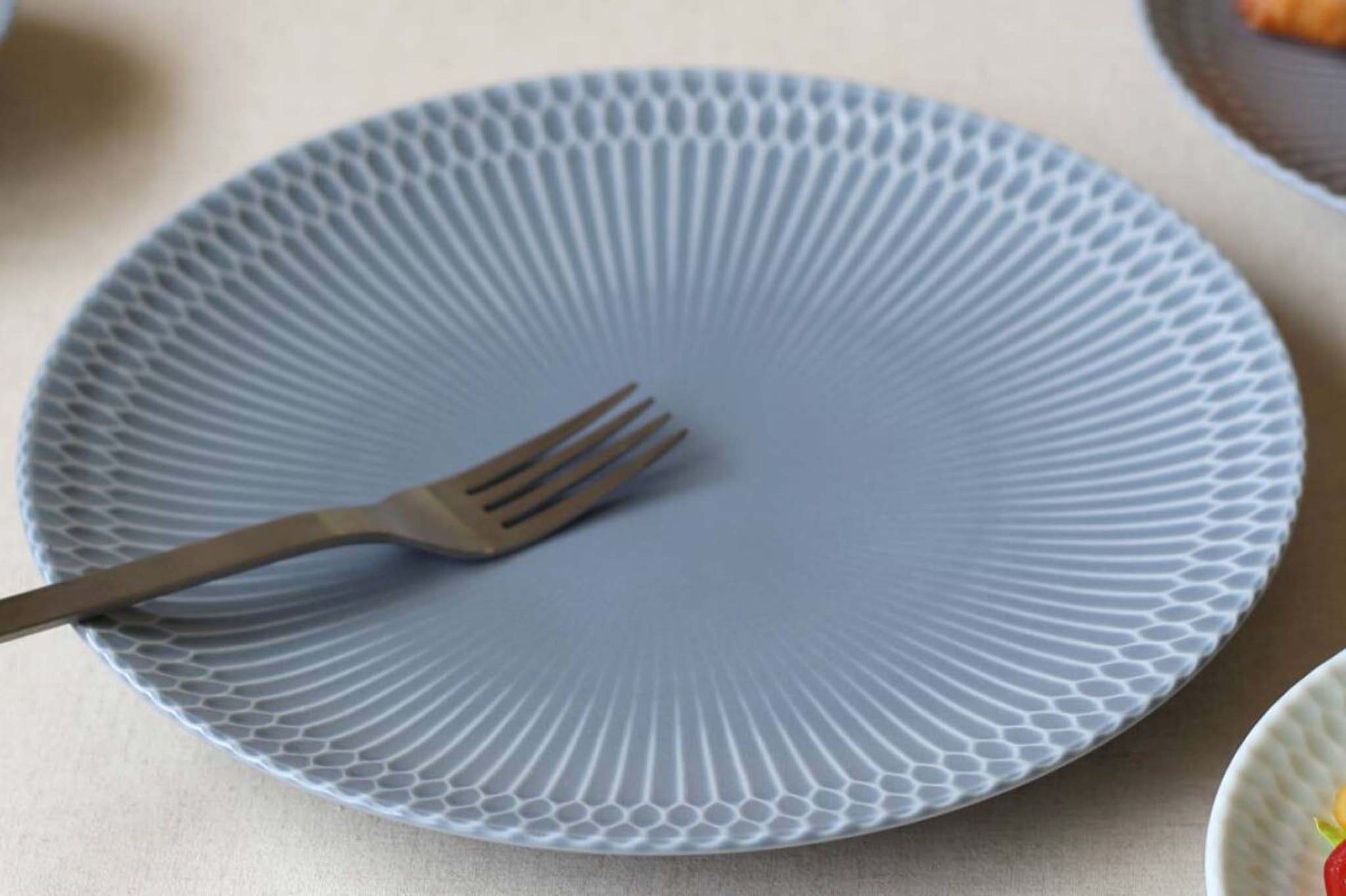 伝統的なしのぎ文様の繊細なレリーフが、料理を優しく彩る華やかな器です。皿はゆったりとした深さで毎日の食卓で活躍します。