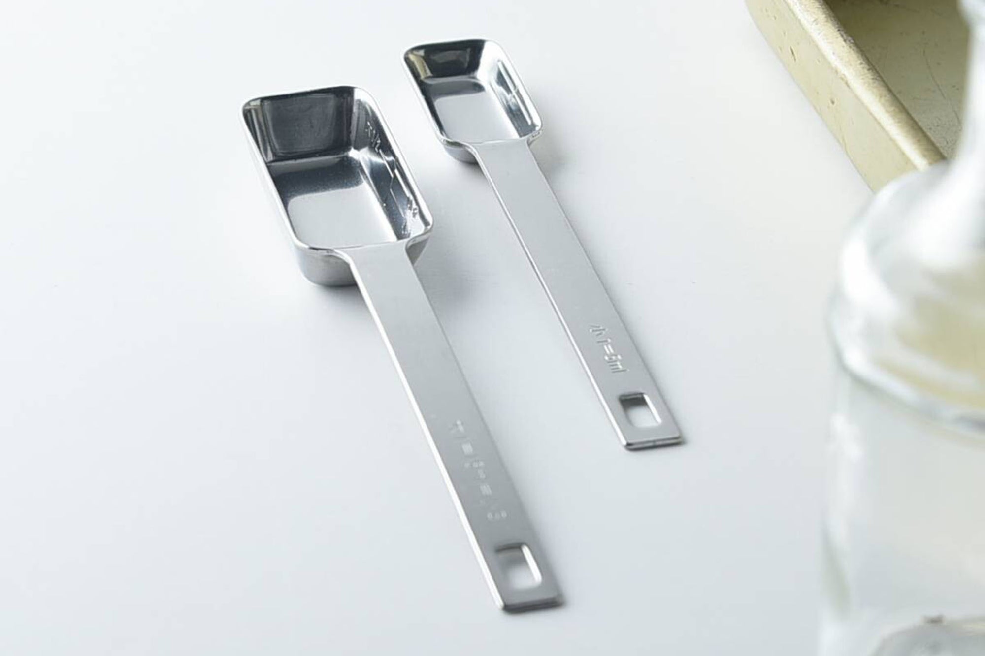 既存の計量スプーンの悩み事は、口の小さな容器には入らないことが多い事。そして、プラスティックややわらかいステンレスだと味噌や練りごまなどの固い調味料を取るときに曲がってしまうことがある事でした。いつもの計量スプーンにも少しずつ使いづらいところがある部分を、プロの目で見て徹底的に使いやすさを追求したのがこの「四角い計量スプーン」です。