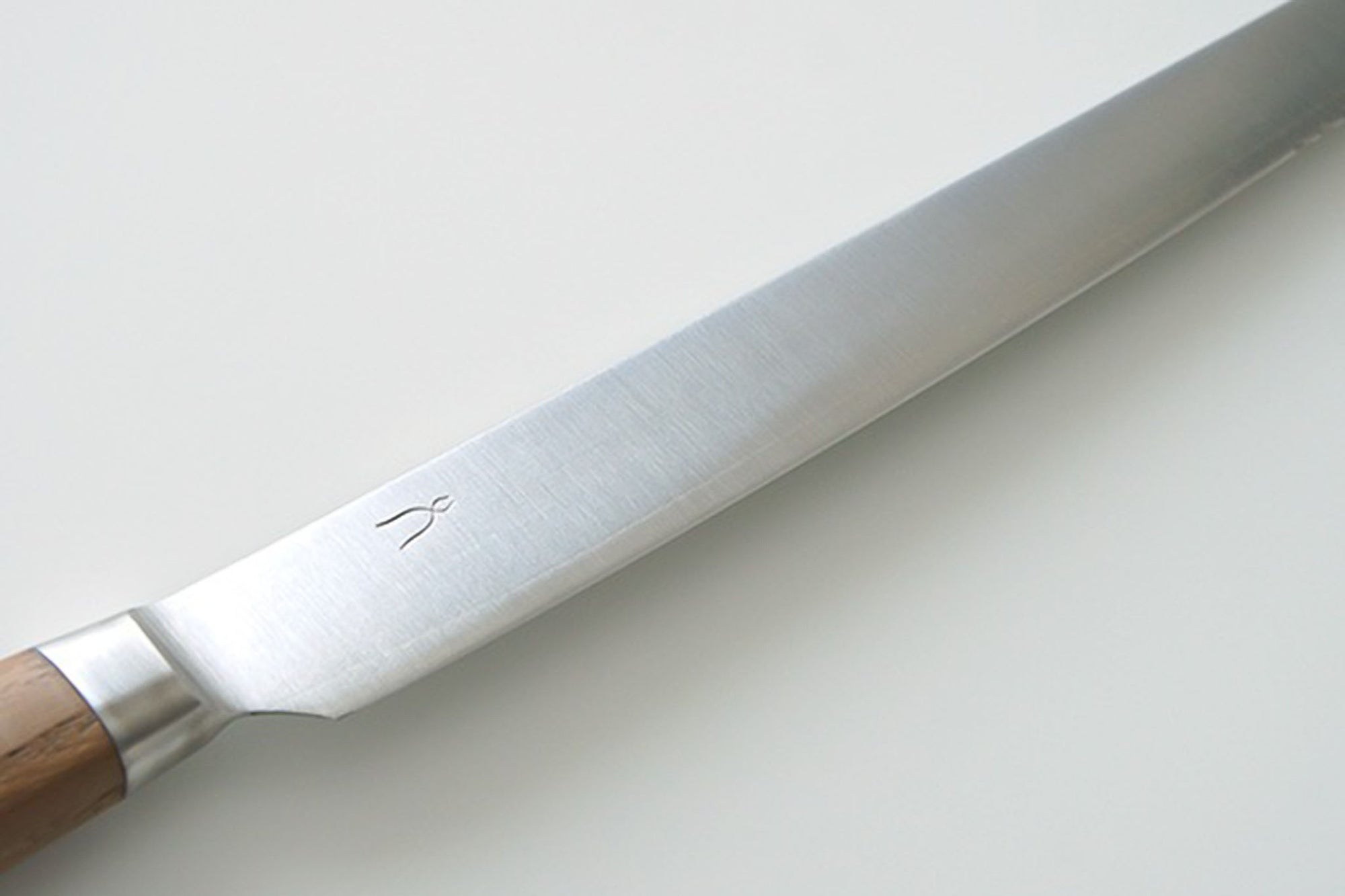 こちらの庖丁の特徴は、なんといっても「波刃ではない」パン切り庖丁の"切れ味"です。パンの切り口がなめらかで、パンくずがほとんどでません。刃が落ちる感じに切れ、思わず何枚も切りたくなる切れ味。断面がボソボソとしないため、バターやジャムも塗りやすく、サンドイッチのパンの耳落としも手を添える程度で切り落とせます。フランスパンのような皮が硬めのパンも先端部の波刃できっかけをつくることですっと切れるようになっています。堅くて腐りにくい栗材。さらに、その栗材をタダフサの特許技術から生まれた抗菌炭化木にしたものをハンドルに使用しています。木材そのものの質感を残した抗菌炭化木は、炭の一歩手前の状態にして菌が繁殖出来なくなり死滅してしまう木材です。また刃の部分は、ステンレス並みのクロームや炭素、モリブデン、バナジュウム等を含有する硬く粘りのある特殊合金を使用。鋭い切れ味を保ちやすいのが特長です。