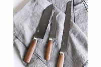 肉・魚・野菜の調理に使用できることから「三徳」と呼ばれている万能庖丁です。先が尖っているので、幅広い用途があり、ご家庭で一番多く使われている庖丁です。軽くて扱いやすく、トマトもスパッと切れる 切れ味。女性の手に馴染みやい丸みを帯びたハンドルも扱いやすさのポイント。堅くて腐りにくい栗材。さらに、その栗材をタダフサの特許技術から生まれた抗菌炭化木にしたものをハンドルに使用しています。木材そのものの質感を残した抗菌炭化木は、炭の一歩手前の状態にして菌が繁殖出来なくなり死滅してしまう木材です。また刃の部分は、ステンレス並みのクロームや炭素、モリブデン、バナジュウム等を含有する硬く粘りのある特殊合金を使用。鋭い切れ味を保ちやすいのが特長です。