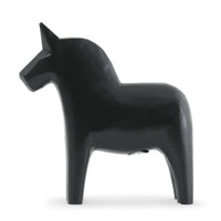 Grannas A. Olsson Hemslojd（グランナス オルソン ヘムスロイド）は、1922年にスウェーデン・ダーラナ地方ヌスナスで創業した世界最古のダラホース工房です。創業者のアンダース オルソン氏は、当初家族経営のパン屋から木工品製造へと転換し、弟らと協力してダラホースの生産を始めました。ひとつずつ選別されたスロースギ材（シルヤン湖周辺の赤松）を使い、木型の挽きから手彫り、下地塗装、さらに熟練のリップル（波模様）ペインターによるフリーハンド装飾を施します。その後、丁寧にニス仕上げされ、赤や白、青など伝統色に彩られた馬たちは、まさに「スウェーデンの象徴」として世界中の家庭や店舗に愛されています。伝統工房としての格式を受け継ぎつつも、パステルやモノトーン、限定柄などを加えることで、現代のインテリアにもマッチするデザイン性も追求しています。