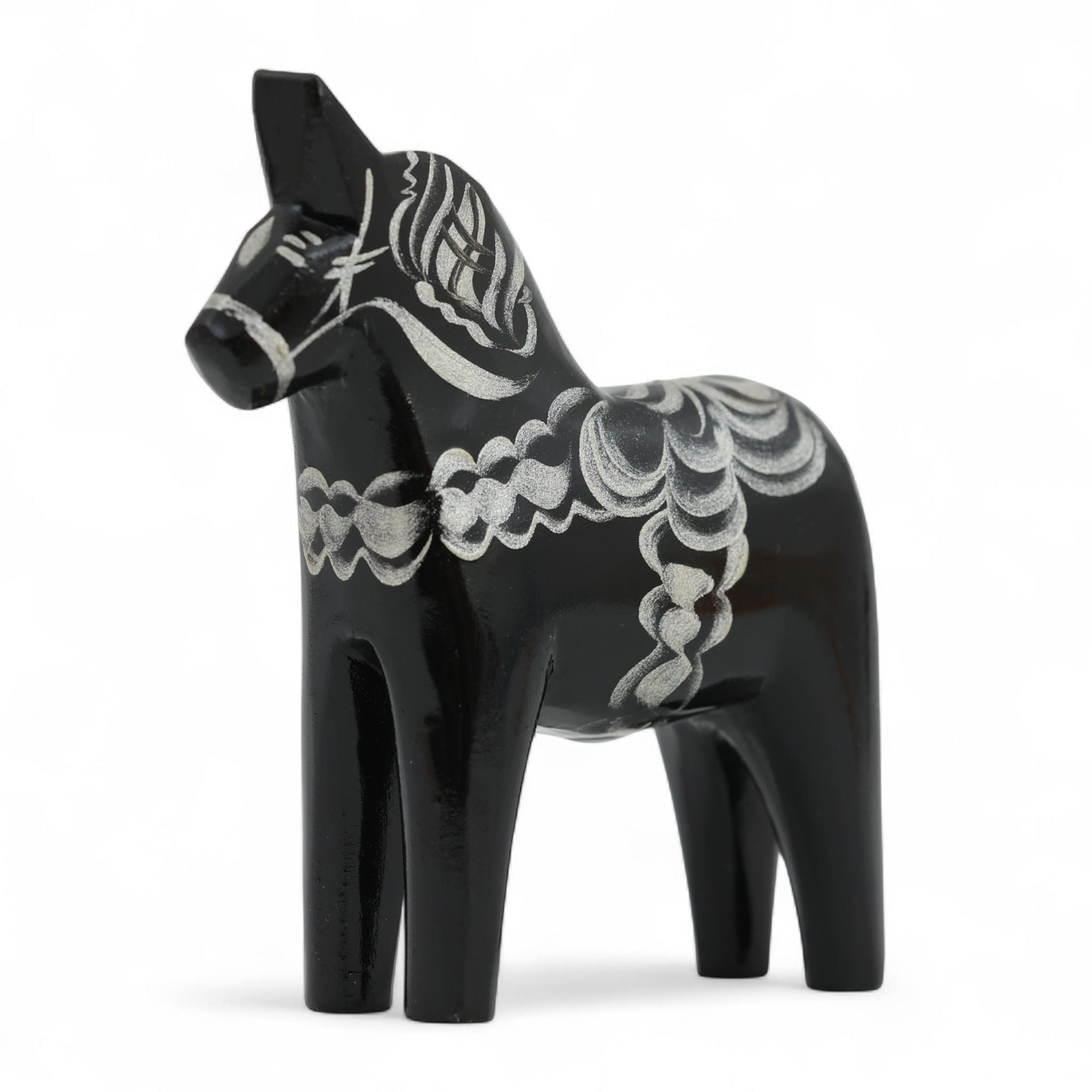 Grannas A. Olsson Hemslojd（グランナス オルソン ヘムスロイド）は、1922年にスウェーデン・ダーラナ地方ヌスナスで創業した世界最古のダラホース工房です。創業者のアンダース オルソン氏は、当初家族経営のパン屋から木工品製造へと転換し、弟らと協力してダラホースの生産を始めました。ひとつずつ選別されたスロースギ材（シルヤン湖周辺の赤松）を使い、木型の挽きから手彫り、下地塗装、さらに熟練のリップル（波模様）ペインターによるフリーハンド装飾を施します。その後、丁寧にニス仕上げされ、赤や白、青など伝統色に彩られた馬たちは、まさに「スウェーデンの象徴」として世界中の家庭や店舗に愛されています。伝統工房としての格式を受け継ぎつつも、パステルやモノトーン、限定柄などを加えることで、現代のインテリアにもマッチするデザイン性も追求しています。