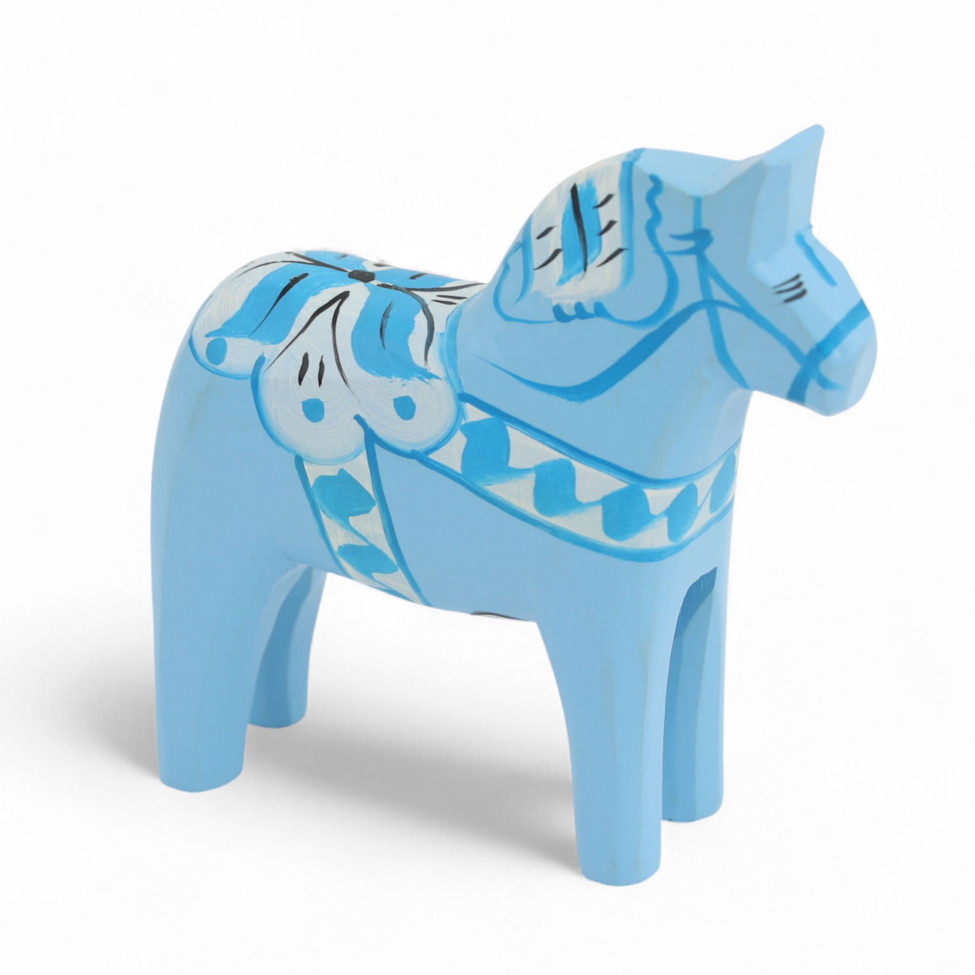 Grannas A. Olsson Hemslojd（グランナス オルソン ヘムスロイド）は、1922年にスウェーデン・ダーラナ地方ヌスナスで創業した世界最古のダラホース工房です。創業者のアンダース オルソン氏は、当初家族経営のパン屋から木工品製造へと転換し、弟らと協力してダラホースの生産を始めました。ひとつずつ選別されたスロースギ材（シルヤン湖周辺の赤松）を使い、木型の挽きから手彫り、下地塗装、さらに熟練のリップル（波模様）ペインターによるフリーハンド装飾を施します。その後、丁寧にニス仕上げされ、赤や白、青など伝統色に彩られた馬たちは、まさに「スウェーデンの象徴」として世界中の家庭や店舗に愛されています。伝統工房としての格式を受け継ぎつつも、パステルやモノトーン、限定柄などを加えることで、現代のインテリアにもマッチするデザイン性も追求しています。