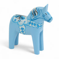 Grannas A. Olsson Hemslojd（グランナス オルソン ヘムスロイド）は、1922年にスウェーデン・ダーラナ地方ヌスナスで創業した世界最古のダラホース工房です。創業者のアンダース オルソン氏は、当初家族経営のパン屋から木工品製造へと転換し、弟らと協力してダラホースの生産を始めました。ひとつずつ選別されたスロースギ材（シルヤン湖周辺の赤松）を使い、木型の挽きから手彫り、下地塗装、さらに熟練のリップル（波模様）ペインターによるフリーハンド装飾を施します。その後、丁寧にニス仕上げされ、赤や白、青など伝統色に彩られた馬たちは、まさに「スウェーデンの象徴」として世界中の家庭や店舗に愛されています。伝統工房としての格式を受け継ぎつつも、パステルやモノトーン、限定柄などを加えることで、現代のインテリアにもマッチするデザイン性も追求しています。