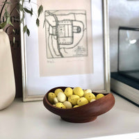 彫刻的なFJボウルは、1951年にデザインされたチンウッド・ボウル・シリーズの中でも最も小さいものです。フィンランドの有名な木製と形と色のバランスの取れた有機的な調和が特長です。材料を最も自然に見せるために、Juhlはティークウッドの有機的なテクスチャと楕円形のうねりのあるリムを対照して脆弱な平衡を打ちます。天然木のシンプルさは幾何学的な複雑さと並置されており、インテリアの設計時に目を引く美しいハーモニーを生み出しています。 FJボウルはチーク材の片から作られた手であり、透明なチークオイルで処理されています。