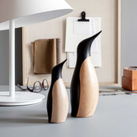 ペンギンは、当初、銀細工師であったハンス・ブンデが自身の大きな姉妹への特別なプレゼントとして1954年に手作りの3羽をデザインしたものです。ハンス・ブンデは、自身の姉妹への愛情と、つがいになった相手に献身的に尽くし生涯添い遂げる一風変わった鳥、ペンギンに魅惑されている自身の気持ちをこめてデザインしました。60年以上の年月が経った今日、3羽のペンギンファミリーの中から、大きなペンギンに小さなペンギンが寄り添う家族の絆の強さを象徴するような2羽を世に送り出せることとなりました。1羽でも、群れをなしていても、並べ方一つでペンギンのエレガントで凛とした佇まいは、家族の絆、そして愛と友情を象徴しています。木目が美しいビーチ材を用いられたペンギンは一つ一つが個性を持っています。