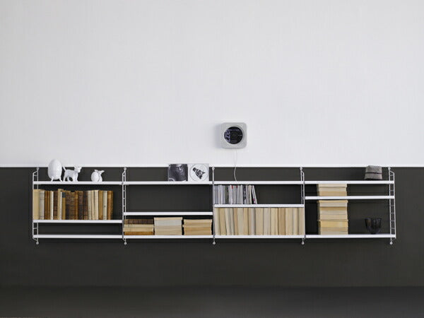 北欧スウェーデンデザインのストリングポケットシェルフ。CDや文庫本などを見た目にも美しく収納できるスリムな棚です。ストリングは拡張性に優れており自分の好み通りフレキシブルに組み合わせることが可能です。また軽量化にも優れており扱いやすい半面十分な安定性を兼ね備えています。北欧の家庭では大変人気のある棚であり、オフィスレイアウトなどにも適しています。空間に配置することにより、部屋に圧迫感を与えないのも特徴です。日本の住宅に取り付ける場合、ネジを取り付ける箇所の壁紙を予め1cm各程度小さく剥がしておき、ネジを取り外した際壁紙を再度貼りなおすことで目立たなくすることができると思います。