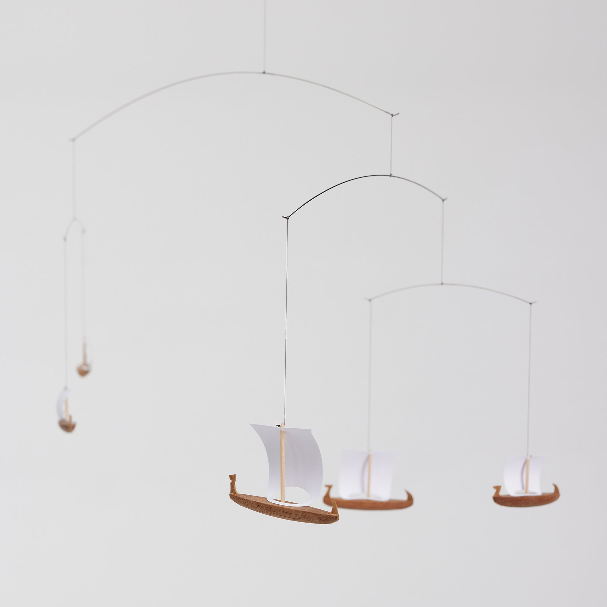 Flensted Mobiles（フレンステッド・モビール）は、1953年創業のデンマーク発・モビール専門ブランド。北欧デザインの文脈に立脚し、造形・質量配分・回転慣性を最適化して、わずかな気流でも自律的に表情を変える構成美を追求します。各パーツは重心とトルクの釣り合いを精密に設計し、静止と運動のあいだを往還する“動く彫刻”として空間に時間軸を付与。代表作「Lucky Storks」から幾何学、鳥類、気球まで多彩で、紙・ステンレス・木材の軽量構造は施工負荷が小さく、住宅・商業・ホスピタリティ・キッズ空間に適合します。現在もデンマーク国内で手作業組立・品質管理を徹底し、視覚ノイズを抑えた運動リズムが集中・鎮静・遊び心をもたらします。北欧インテリアの天井飾りや吊り下げモビールとして、リビング・子供部屋・出産祝いギフトに最適なデンマーク製の正規品です。