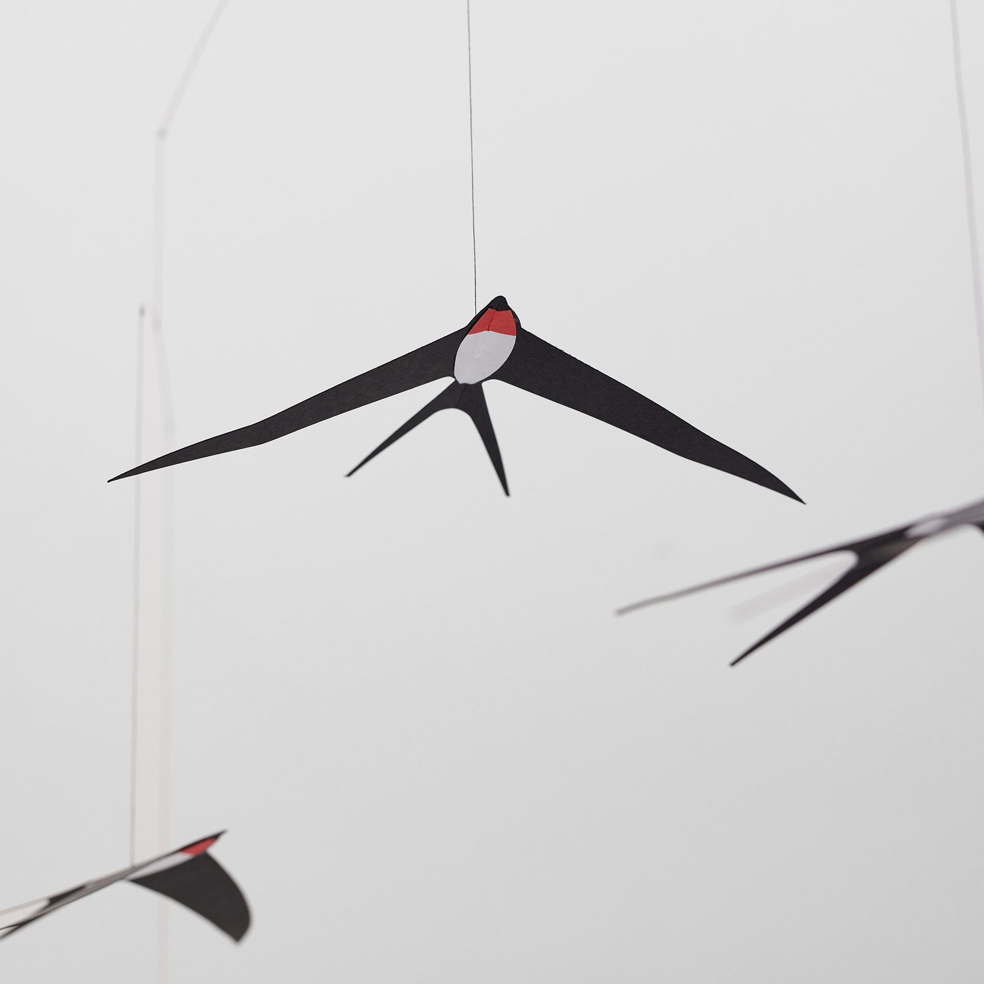 Flensted Mobiles（フレンステッド・モビール）は、1953年創業のデンマーク発・モビール専門ブランド。北欧デザインの文脈に立脚し、造形・質量配分・回転慣性を最適化して、わずかな気流でも自律的に表情を変える構成美を追求します。各パーツは重心とトルクの釣り合いを精密に設計し、静止と運動のあいだを往還する“動く彫刻”として空間に時間軸を付与。代表作「Lucky Storks」から幾何学、鳥類、気球まで多彩で、紙・ステンレス・木材の軽量構造は施工負荷が小さく、住宅・商業・ホスピタリティ・キッズ空間に適合します。現在もデンマーク国内で手作業組立・品質管理を徹底し、視覚ノイズを抑えた運動リズムが集中・鎮静・遊び心をもたらします。北欧インテリアの天井飾りや吊り下げモビールとして、リビング・子供部屋・出産祝いギフトに最適なデンマーク製の正規品です。