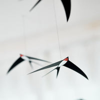 Flensted Mobiles（フレンステッド・モビール）は、1953年創業のデンマーク発・モビール専門ブランド。北欧デザインの文脈に立脚し、造形・質量配分・回転慣性を最適化して、わずかな気流でも自律的に表情を変える構成美を追求します。各パーツは重心とトルクの釣り合いを精密に設計し、静止と運動のあいだを往還する“動く彫刻”として空間に時間軸を付与。代表作「Lucky Storks」から幾何学、鳥類、気球まで多彩で、紙・ステンレス・木材の軽量構造は施工負荷が小さく、住宅・商業・ホスピタリティ・キッズ空間に適合します。現在もデンマーク国内で手作業組立・品質管理を徹底し、視覚ノイズを抑えた運動リズムが集中・鎮静・遊び心をもたらします。北欧インテリアの天井飾りや吊り下げモビールとして、リビング・子供部屋・出産祝いギフトに最適なデンマーク製の正規品です。
