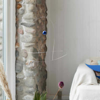 Flensted Mobiles（フレンステッド・モビール）は、1953年創業のデンマーク発・モビール専門ブランド。北欧デザインの文脈に立脚し、造形・質量配分・回転慣性を最適化して、わずかな気流でも自律的に表情を変える構成美を追求します。各パーツは重心とトルクの釣り合いを精密に設計し、静止と運動のあいだを往還する“動く彫刻”として空間に時間軸を付与。代表作「Lucky Storks」から幾何学、鳥類、気球まで多彩で、紙・ステンレス・木材の軽量構造は施工負荷が小さく、住宅・商業・ホスピタリティ・キッズ空間に適合します。現在もデンマーク国内で手作業組立・品質管理を徹底し、視覚ノイズを抑えた運動リズムが集中・鎮静・遊び心をもたらします。北欧インテリアの天井飾りや吊り下げモビールとして、リビング・子供部屋・出産祝いギフトに最適なデンマーク製の正規品です。