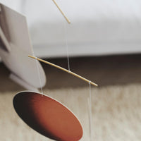 Flensted Mobiles（フレンステッド・モビール）は、1953年創業のデンマーク発・モビール専門ブランド。北欧デザインの文脈に立脚し、造形・質量配分・回転慣性を最適化して、わずかな気流でも自律的に表情を変える構成美を追求します。各パーツは重心とトルクの釣り合いを精密に設計し、静止と運動のあいだを往還する“動く彫刻”として空間に時間軸を付与。代表作「Lucky Storks」から幾何学、鳥類、気球まで多彩で、紙・ステンレス・木材の軽量構造は施工負荷が小さく、住宅・商業・ホスピタリティ・キッズ空間に適合します。現在もデンマーク国内で手作業組立・品質管理を徹底し、視覚ノイズを抑えた運動リズムが集中・鎮静・遊び心をもたらします。北欧インテリアの天井飾りや吊り下げモビールとして、リビング・子供部屋・出産祝いギフトに最適なデンマーク製の正規品です。