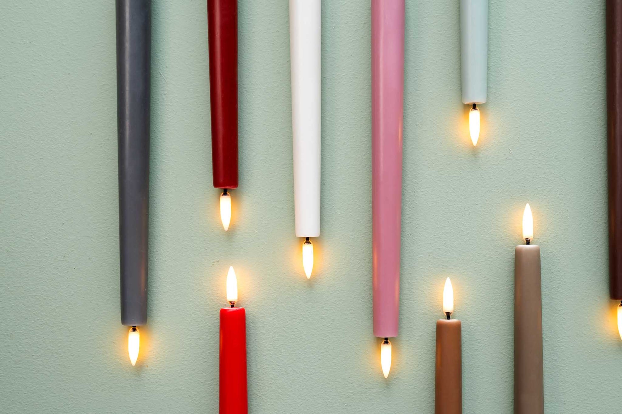 UYUNI Lighting（ウユニ・ライティング）は、デンマークのLEDで本物のキャンドル体験を再現するライティングブランドです。最大の魅力は、特許取得のユニークな「3Dフレーム（炎）」と、目で追ってしまうほど自然なフリッカー表現。灯りの芯が立ち上がるように見える立体的な炎は、見る角度によって表情が変わり、テーブル上のガラス器や壁面に繊細な陰影を落とします。見た目はクラシック、手触りはラグジュアリー、内部機構はイノベーティブ、伝統的なキャンドルの佇まいを、現代のテクノロジーで静かにアップデートしました。外装には本物のワックス（パラフィン加工の表面仕上げ）を用い、日中に置いてあるだけでも上質なオブジェのような存在感。夜は色温度のやさしい光で、北欧らしいhygge（ヒュッゲ）の空気を手軽にまとえます。インテリアの審美眼に応えるプロップとして完成度の高いLEDキャンドルです。