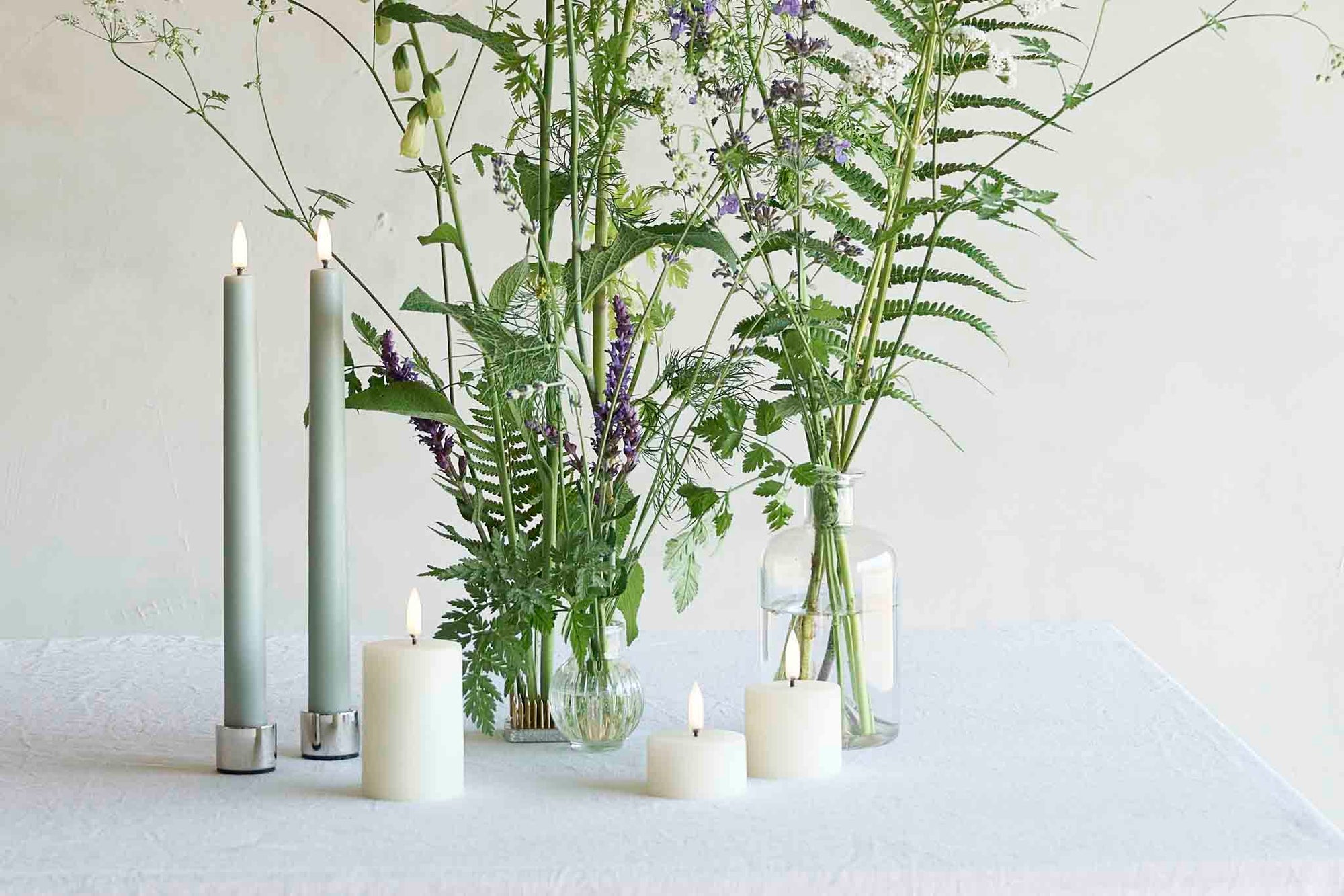 UYUNI Lighting（ウユニ・ライティング）は、デンマークのLEDで本物のキャンドル体験を再現するライティングブランドです。最大の魅力は、特許取得のユニークな「3Dフレーム（炎）」と、目で追ってしまうほど自然なフリッカー表現。灯りの芯が立ち上がるように見える立体的な炎は、見る角度によって表情が変わり、テーブル上のガラス器や壁面に繊細な陰影を落とします。見た目はクラシック、手触りはラグジュアリー、内部機構はイノベーティブ、伝統的なキャンドルの佇まいを、現代のテクノロジーで静かにアップデートしました。外装には本物のワックス（パラフィン加工の表面仕上げ）を用い、日中に置いてあるだけでも上質なオブジェのような存在感。夜は色温度のやさしい光で、北欧らしいhygge（ヒュッゲ）の空気を手軽にまとえます。インテリアの審美眼に応えるプロップとして完成度の高いLEDキャンドルです。