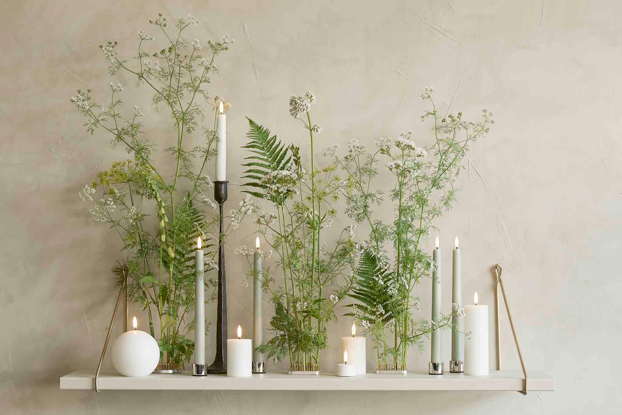 UYUNI Lighting（ウユニ・ライティング）は、デンマークのLEDで本物のキャンドル体験を再現するライティングブランドです。最大の魅力は、特許取得のユニークな「3Dフレーム（炎）」と、目で追ってしまうほど自然なフリッカー表現。灯りの芯が立ち上がるように見える立体的な炎は、見る角度によって表情が変わり、テーブル上のガラス器や壁面に繊細な陰影を落とします。見た目はクラシック、手触りはラグジュアリー、内部機構はイノベーティブ、伝統的なキャンドルの佇まいを、現代のテクノロジーで静かにアップデートしました。外装には本物のワックス（パラフィン加工の表面仕上げ）を用い、日中に置いてあるだけでも上質なオブジェのような存在感。夜は色温度のやさしい光で、北欧らしいhygge（ヒュッゲ）の空気を手軽にまとえます。インテリアの審美眼に応えるプロップとして完成度の高いLEDキャンドルです。