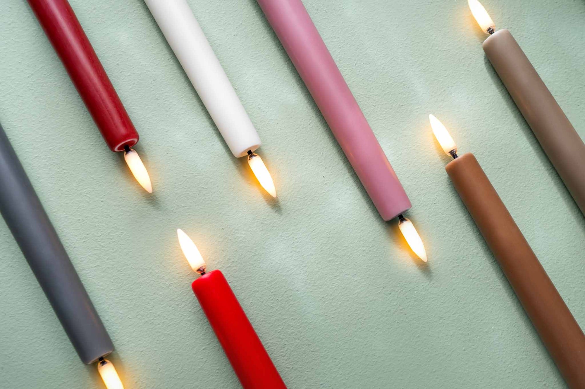 UYUNI Lighting（ウユニ・ライティング）は、デンマークのLEDで本物のキャンドル体験を再現するライティングブランドです。最大の魅力は、特許取得のユニークな「3Dフレーム（炎）」と、目で追ってしまうほど自然なフリッカー表現。灯りの芯が立ち上がるように見える立体的な炎は、見る角度によって表情が変わり、テーブル上のガラス器や壁面に繊細な陰影を落とします。見た目はクラシック、手触りはラグジュアリー、内部機構はイノベーティブ、伝統的なキャンドルの佇まいを、現代のテクノロジーで静かにアップデートしました。外装には本物のワックス（パラフィン加工の表面仕上げ）を用い、日中に置いてあるだけでも上質なオブジェのような存在感。夜は色温度のやさしい光で、北欧らしいhygge（ヒュッゲ）の空気を手軽にまとえます。インテリアの審美眼に応えるプロップとして完成度の高いLEDキャンドルです。
