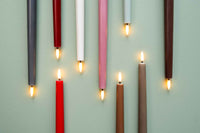 UYUNI Lighting（ウユニ・ライティング）は、デンマークのLEDで本物のキャンドル体験を再現するライティングブランドです。最大の魅力は、特許取得のユニークな「3Dフレーム（炎）」と、目で追ってしまうほど自然なフリッカー表現。灯りの芯が立ち上がるように見える立体的な炎は、見る角度によって表情が変わり、テーブル上のガラス器や壁面に繊細な陰影を落とします。見た目はクラシック、手触りはラグジュアリー、内部機構はイノベーティブ、伝統的なキャンドルの佇まいを、現代のテクノロジーで静かにアップデートしました。外装には本物のワックス（パラフィン加工の表面仕上げ）を用い、日中に置いてあるだけでも上質なオブジェのような存在感。夜は色温度のやさしい光で、北欧らしいhygge（ヒュッゲ）の空気を手軽にまとえます。インテリアの審美眼に応えるプロップとして完成度の高いLEDキャンドルです。
