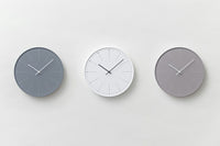 数字の代わりにタンポポ（＝dandelion）の綿毛の本数によって時刻を伝える掛け時計です。綿毛がふわふわと風に舞い散るように、流れ続ける時を表現しています。タンポポの綿毛をモチーフにした繊細なデザインが特徴のこの時計は、シルク印刷の限界とされる本体枠の際から8ｍｍの場所まで印刷することによって、時計盤面いっぱいに綿毛が舞い散るイメージを再現しています。また、樹脂枠の肉厚を通常よりも厚い4ｍｍにし、適度な重量を持たせることで、心地よい重さを感じます。カラーバリエーションは、ホワイト・グレー・ベージュの3色展開。アースカラーの落ち着いた色合いが、優しい印象を与えてくれます。