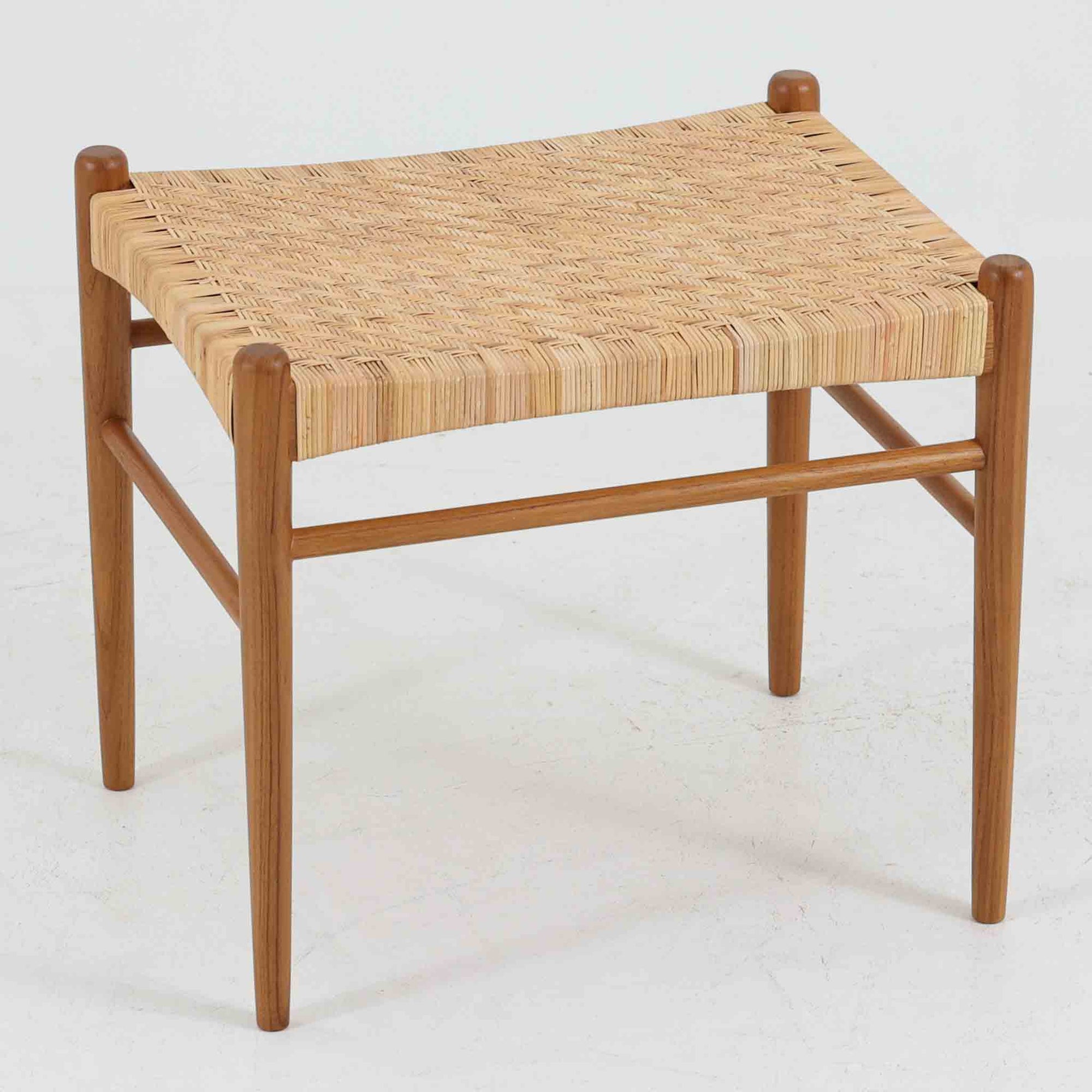 北欧デザインのスツールです。上質なチーク材フレームを丁寧に削り、シャープでスタイリッシュですが、柔らかい表情も持ち合わせたデザインに仕上げています。また、軽量ですが、しっかりとした造りになっています。座面の籐（ラタン）は上質で天然なもので細かい網目状に時間をかけて編み込まれています。使い込むほどにあめ色に変化し馴染んでくるのも天然素材の大きな魅力です。お部屋の片隅にクッションなどを添えて置いておくだけでもおしゃれです。必要なときにすっと出して使えます。複数スタッキングできるのも嬉しいです。