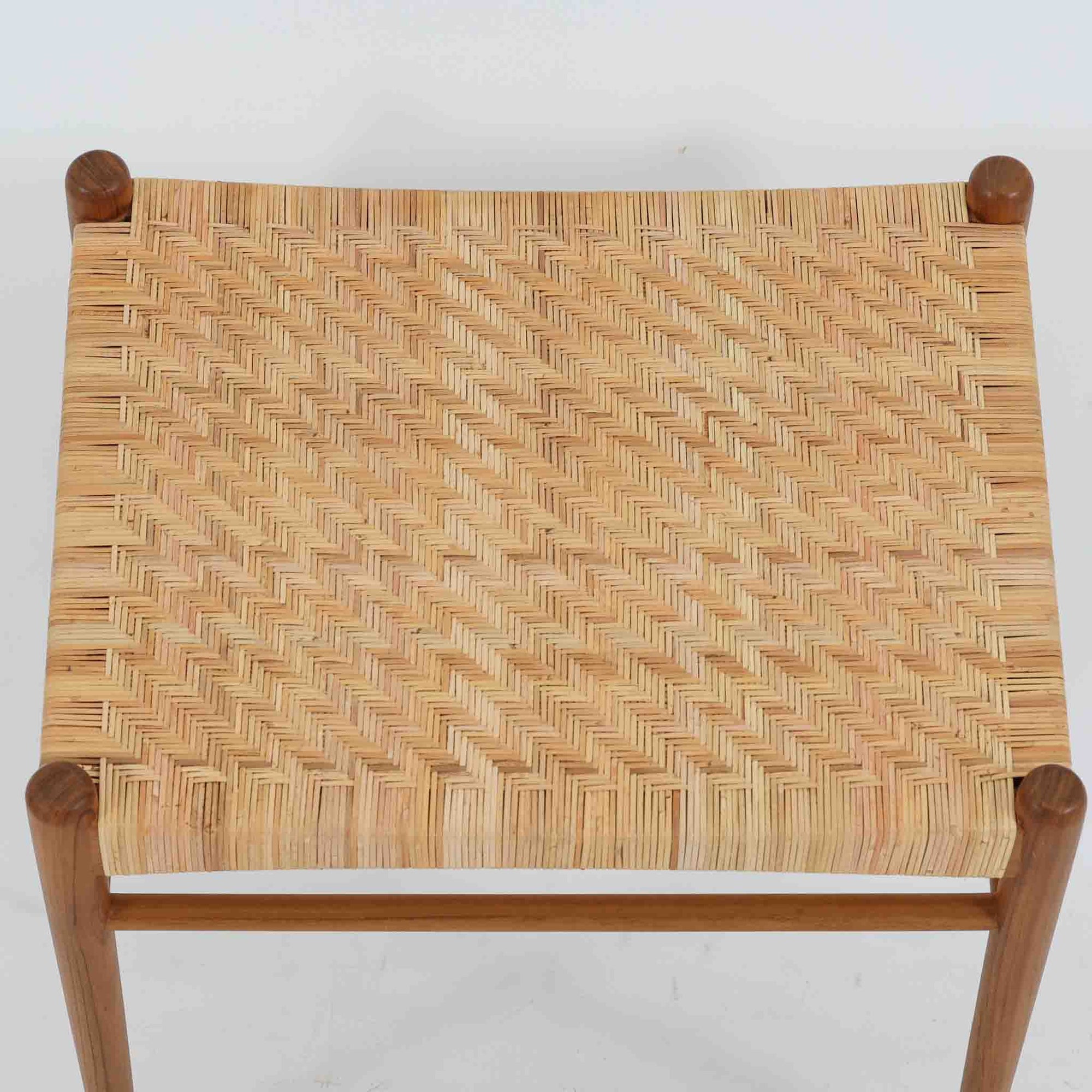 北欧デザインのスツールです。上質なチーク材フレームを丁寧に削り、シャープでスタイリッシュですが、柔らかい表情も持ち合わせたデザインに仕上げています。また、軽量ですが、しっかりとした造りになっています。座面の籐（ラタン）は上質で天然なもので細かい網目状に時間をかけて編み込まれています。使い込むほどにあめ色に変化し馴染んでくるのも天然素材の大きな魅力です。お部屋の片隅にクッションなどを添えて置いておくだけでもおしゃれです。必要なときにすっと出して使えます。複数スタッキングできるのも嬉しいです。