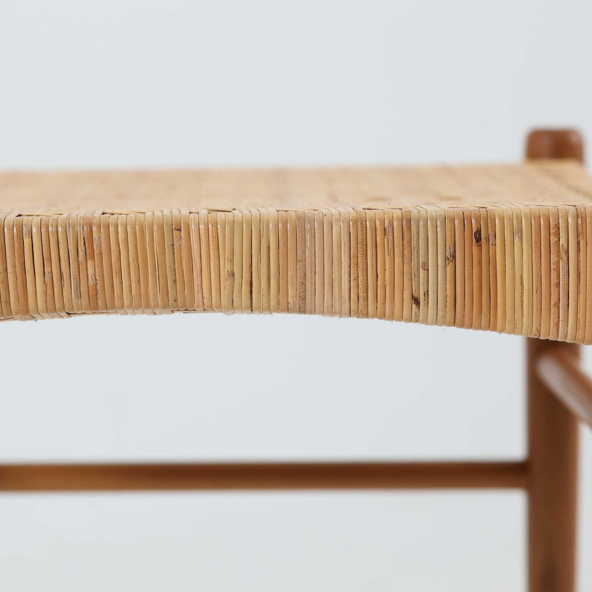 北欧デザインのスツールです。上質なチーク材フレームを丁寧に削り、シャープでスタイリッシュですが、柔らかい表情も持ち合わせたデザインに仕上げています。また、軽量ですが、しっかりとした造りになっています。座面の籐（ラタン）は上質で天然なもので細かい網目状に時間をかけて編み込まれています。使い込むほどにあめ色に変化し馴染んでくるのも天然素材の大きな魅力です。お部屋の片隅にクッションなどを添えて置いておくだけでもおしゃれです。必要なときにすっと出して使えます。複数スタッキングできるのも嬉しいです。