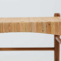 北欧デザインのスツールです。上質なチーク材フレームを丁寧に削り、シャープでスタイリッシュですが、柔らかい表情も持ち合わせたデザインに仕上げています。また、軽量ですが、しっかりとした造りになっています。座面の籐（ラタン）は上質で天然なもので細かい網目状に時間をかけて編み込まれています。使い込むほどにあめ色に変化し馴染んでくるのも天然素材の大きな魅力です。お部屋の片隅にクッションなどを添えて置いておくだけでもおしゃれです。必要なときにすっと出して使えます。複数スタッキングできるのも嬉しいです。