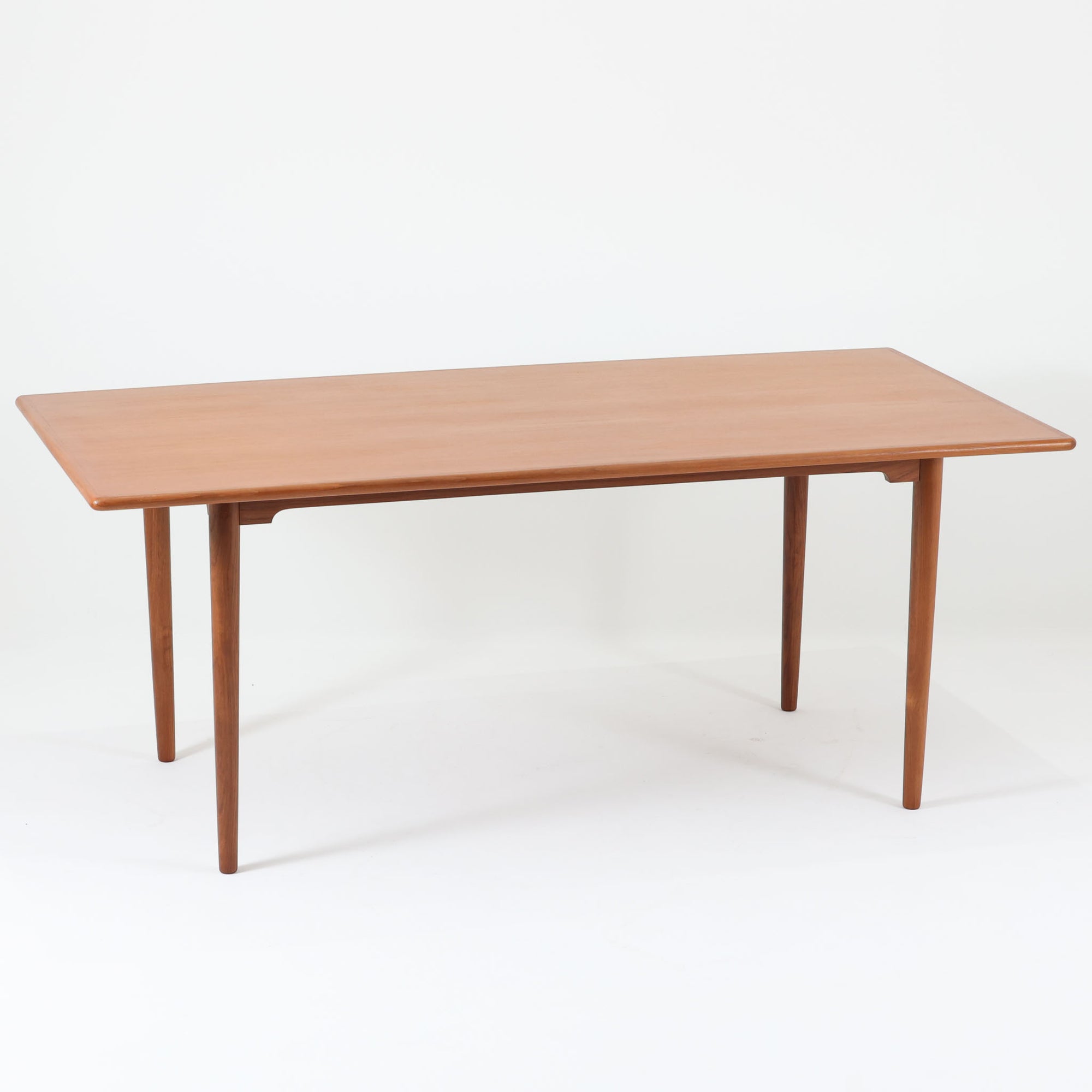 北欧モダンデザイン、180cm幅の大きな６人用ダイニングテーブルです。天板トップには見た目にも美しい上質なチーク突板を使用し、縁には贅沢に無垢材をジョイントしており、耐久力に加え曲線の美しさが際立っています。また、椅子を収納する際に干渉することが多い幕板ですが中央部を浅くすることで、干渉を軽減し、また見た目にも高級感を演出しています。通常安価な材質で仕上げられる幕板や天板裏面にも贅沢にチーク材天然木を使用しております。脚のポジションはやや内側にセットされスタイリッシュなデザインにも仕上がっています。
