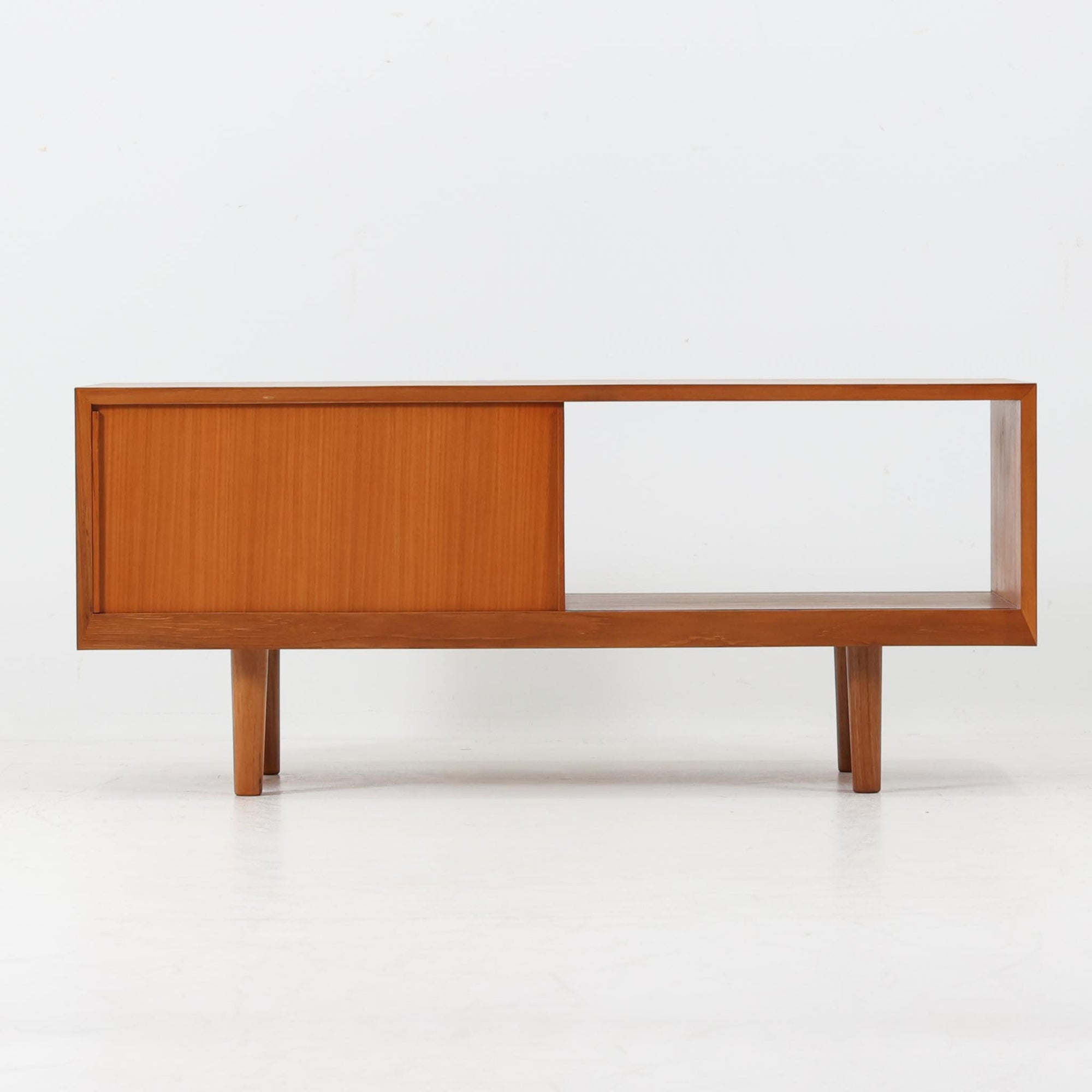 北欧スタイルのＴＶボードです。 極力無駄を省いたシンプルなデザインに仕上げられたフォルムにシャープなレッグがアクセントになっています。材質はチーク材天然木、シンプルながらも高品質な印象を感じることができます。取り外し可能な引き戸は使い勝手がよく、さまざまなタイプの機器などが収納できると思います。こちらは幅の狭いタイプで、小さめのお部屋にも無理なくおしゃれなインテリアとしてご使用いただけると思います。