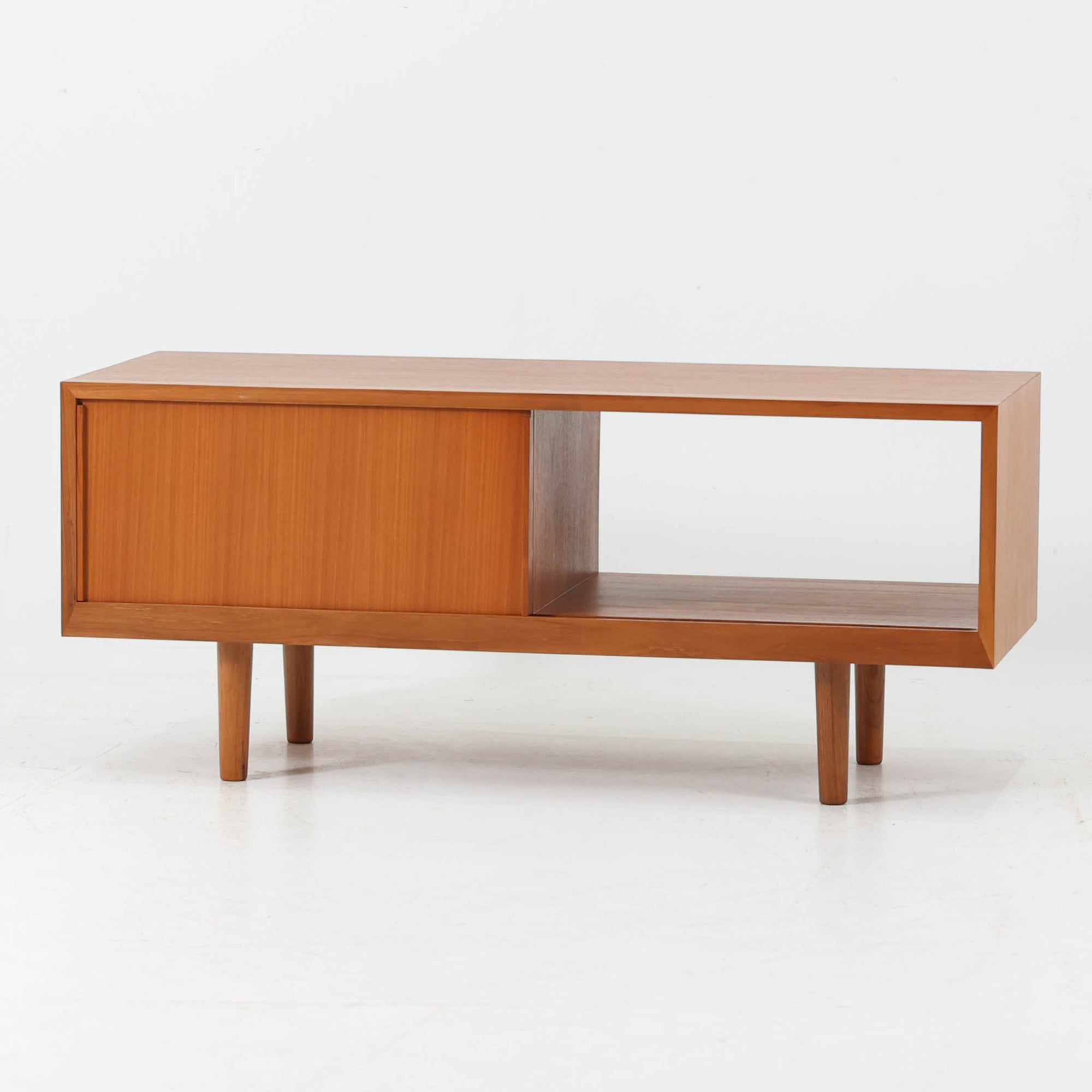 北欧スタイルのＴＶボードです。 極力無駄を省いたシンプルなデザインに仕上げられたフォルムにシャープなレッグがアクセントになっています。材質はチーク材天然木、シンプルながらも高品質な印象を感じることができます。取り外し可能な引き戸は使い勝手がよく、さまざまなタイプの機器などが収納できると思います。こちらは幅の狭いタイプで、小さめのお部屋にも無理なくおしゃれなインテリアとしてご使用いただけると思います。