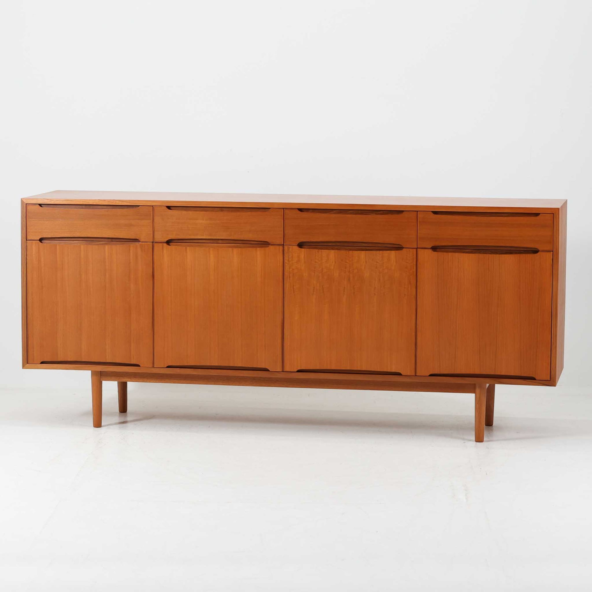 北欧モダンスタイルのワイドキャビネットです。取っ手を葉っぱの形に削りだしているのが特徴的なデザインです。上部には引出収納を４つ、下部には扉収納を２つ備えています。下部収納部の棚板は高さ調整可能、取り外しも可能です。使い勝手も良好で、収納時見た目にも大変上品で美しい雰囲気があります。素材は脚も含め全てチーク材を使用しており、美しい暖かな風合いの木目が心地よさを演出します。少し小さめなのがお部屋を圧迫することもなくおしゃれに演出することが可能です。