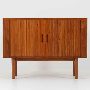 蛇腹式扉を採用した、サイドボードです。機能的にも見た目的にも非常に合理的で美しいのが特徴で、昔のデンマーク家具などには多く採用されていました。通常のものより蛇腹が収納される分内寸が小さくなりますが、その分フルオープンができるのが魅力です。全面蛇腹部分は柾目の突板を使用するのが一般的ですが、稼動しやすさ、耐久度、美しさなどを考慮し、全て無垢材を採用しました。職人により1本1本つなぎ合わせています。