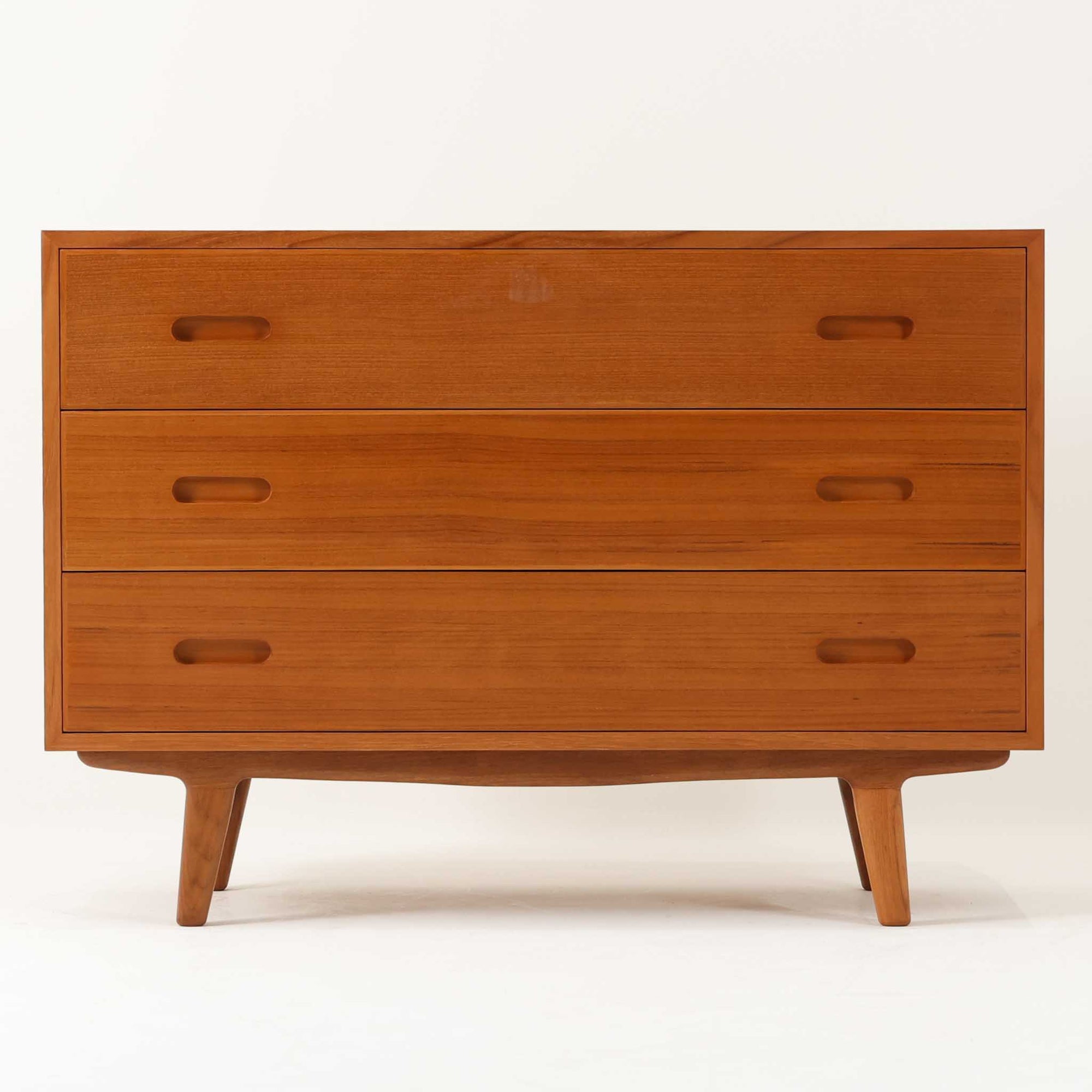 脚がハの字にデザインされたおしゃれなチェストです。3段タイプにしては少し大きめですが、その分十分な収納力があります。木材はチーク材を使用、全面や背面はなどには通常よりも厚めの無垢材をジョイントして、丸みの出るよう削りだしています。これにより丁度いい重量感を演出しています。また、脚部も丁寧に削りだしており、こちらもやわらかい印象を与えてくれるよう仕上げています。手触りなども非常によく高級感があります。