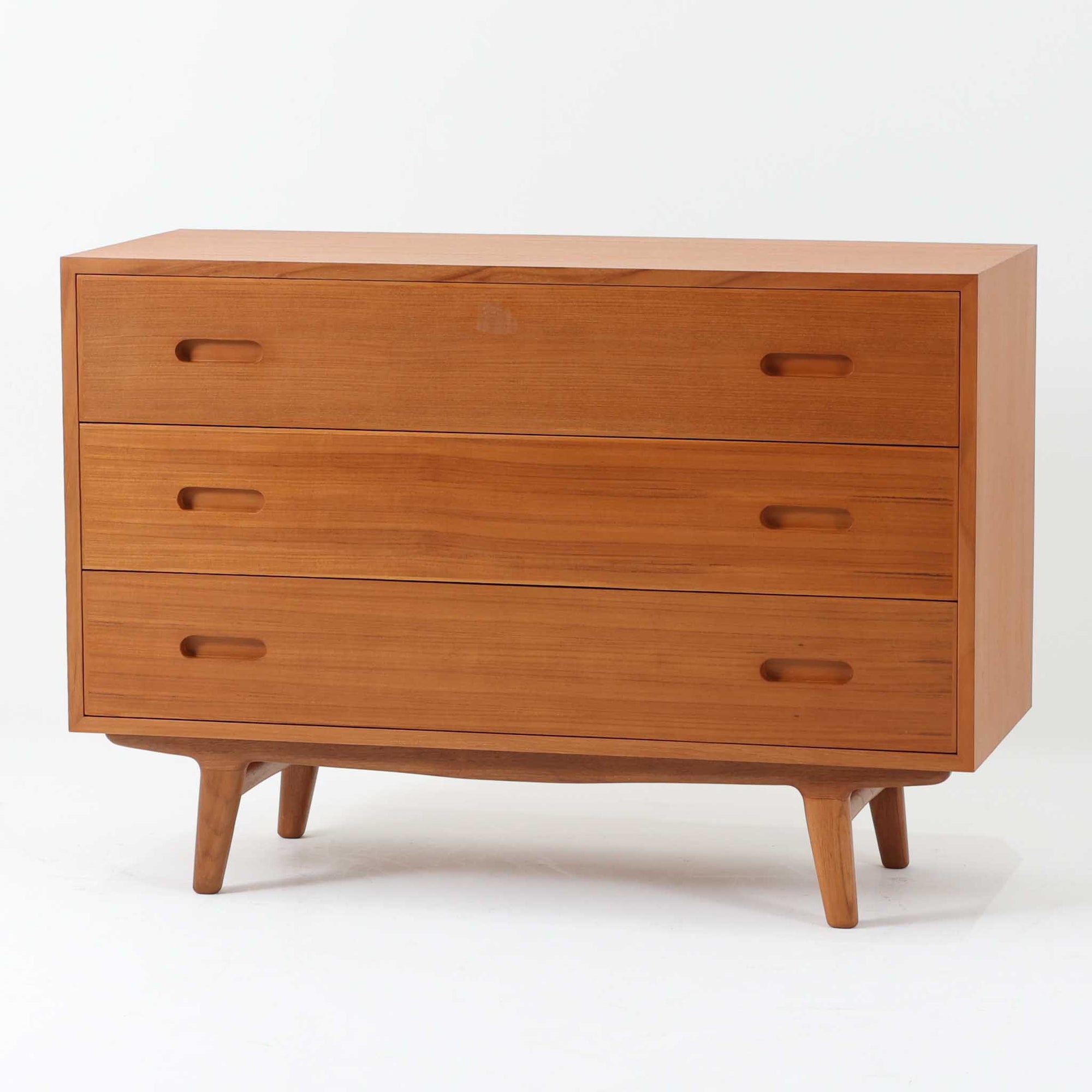 脚がハの字にデザインされたおしゃれなチェストです。3段タイプにしては少し大きめですが、その分十分な収納力があります。木材はチーク材を使用、全面や背面はなどには通常よりも厚めの無垢材をジョイントして、丸みの出るよう削りだしています。これにより丁度いい重量感を演出しています。また、脚部も丁寧に削りだしており、こちらもやわらかい印象を与えてくれるよう仕上げています。手触りなども非常によく高級感があります。