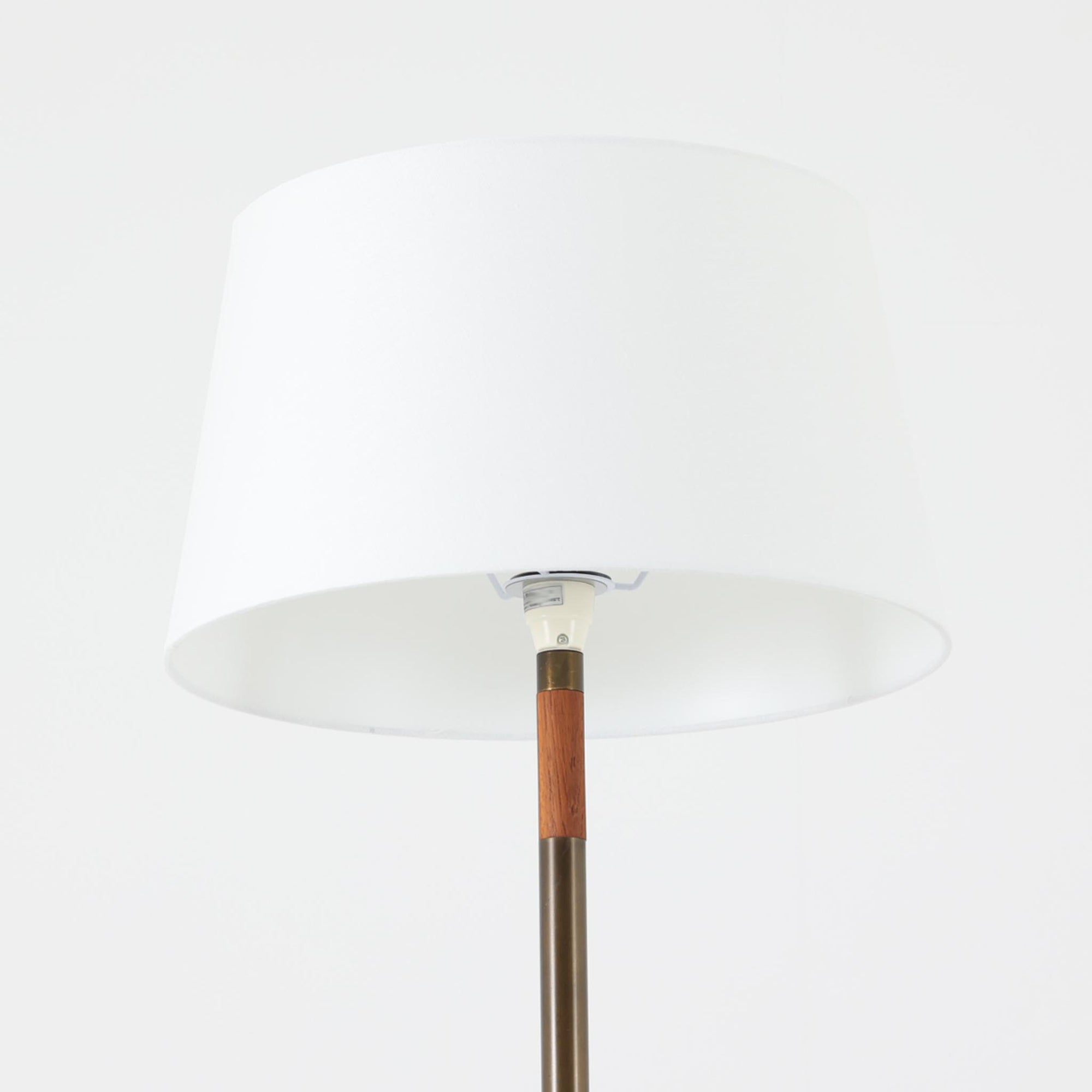 Jo HammerborgがFog &amp; Morupのために手がけた「Monolit」は、真鍮のシャフトにチーク材のアクセントを加えたミニマルで洗練されたフロアランプです。高さ164cmの堂々たるプロポーションに、Y字型の真鍮ベースが独自の存在感を放ち、リネンシェードを通した柔らかな光が空間に落ち着きを与えます。素材のコントラストと構造美が際立つ一台は、北欧ビンテージ照明の中でも特に希少な逸品といえるでしょう。