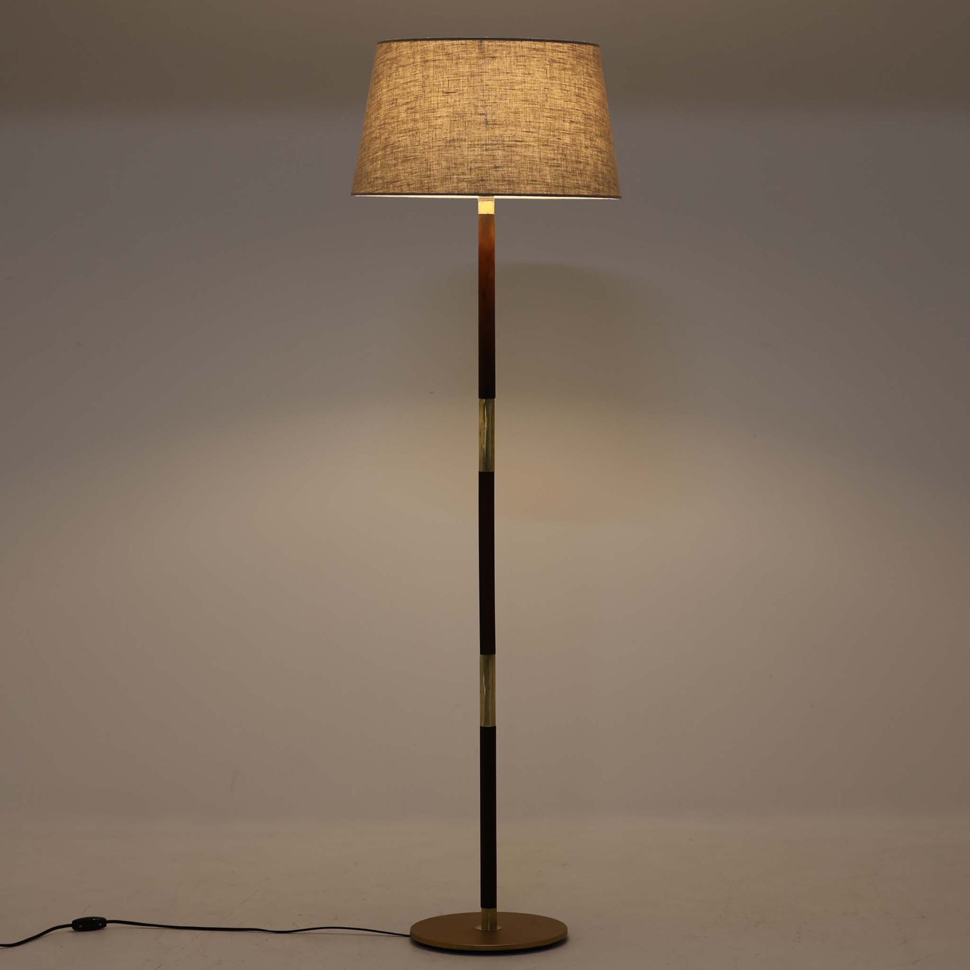 ローズウッド材の落ち着いた木肌と真鍮の輝きが美しく調和したデンマーク製のフロアランプは、直線的な支柱構造により空間をすっきりと演出し、天然リネンのシェードから柔らかな光が広がる上質な佇まいが魅力の北欧ビンテージ家具です。