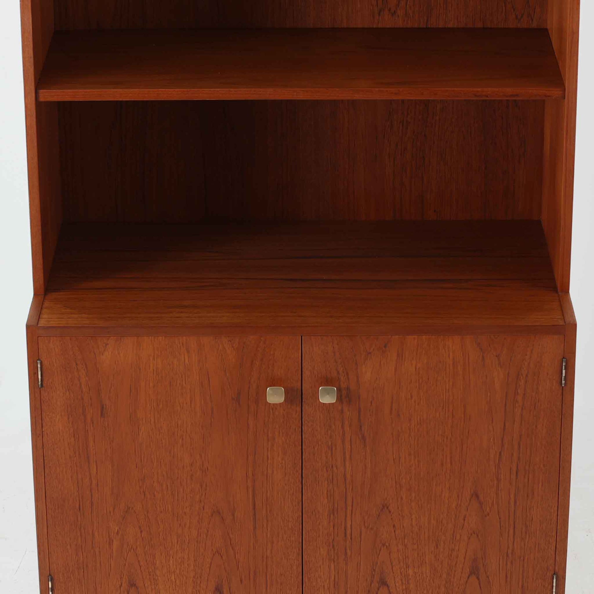 デンマークのHorsens Mobelfabrik社によるディスプレイシェルフは、温かみあるチーク材を使用した端正な佇まいが魅力の一台です。上段には可動棚が4枚備わっており、書籍やオブジェなどのディスプレイに最適です。下段は観音開きの収納扉付きで、見せる収納と隠す収納を両立。すっきりとした脚部構造と洗練された金属取手がアクセントとなり、北欧らしい実用性と美しさを兼ね備えたビンテージ家具です。