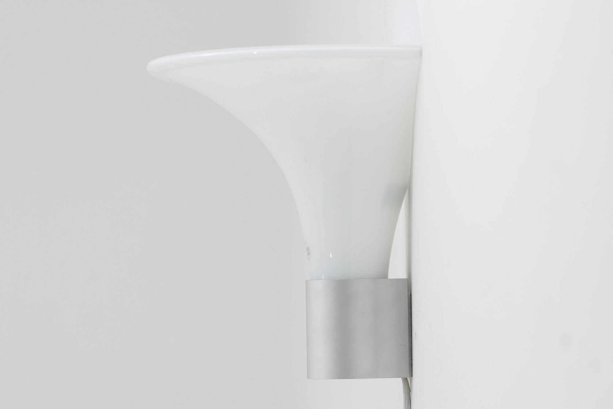 北欧より買い付けました。michael Bangを代表する「mandarin」の中で珍しい壁掛けタイプです。2展開のサイズ展開があった様ですが、こちらは大きいサイズの物。乳白色ガラスならではの優しい光が魅力的です。本製品には、取り付け部の下側にカバーがあるタイプとないタイプがありますが、こちらはアルミ部分に穴が開いており、そこをコードが通るデザインで、アルミにカバーがないタイプです。