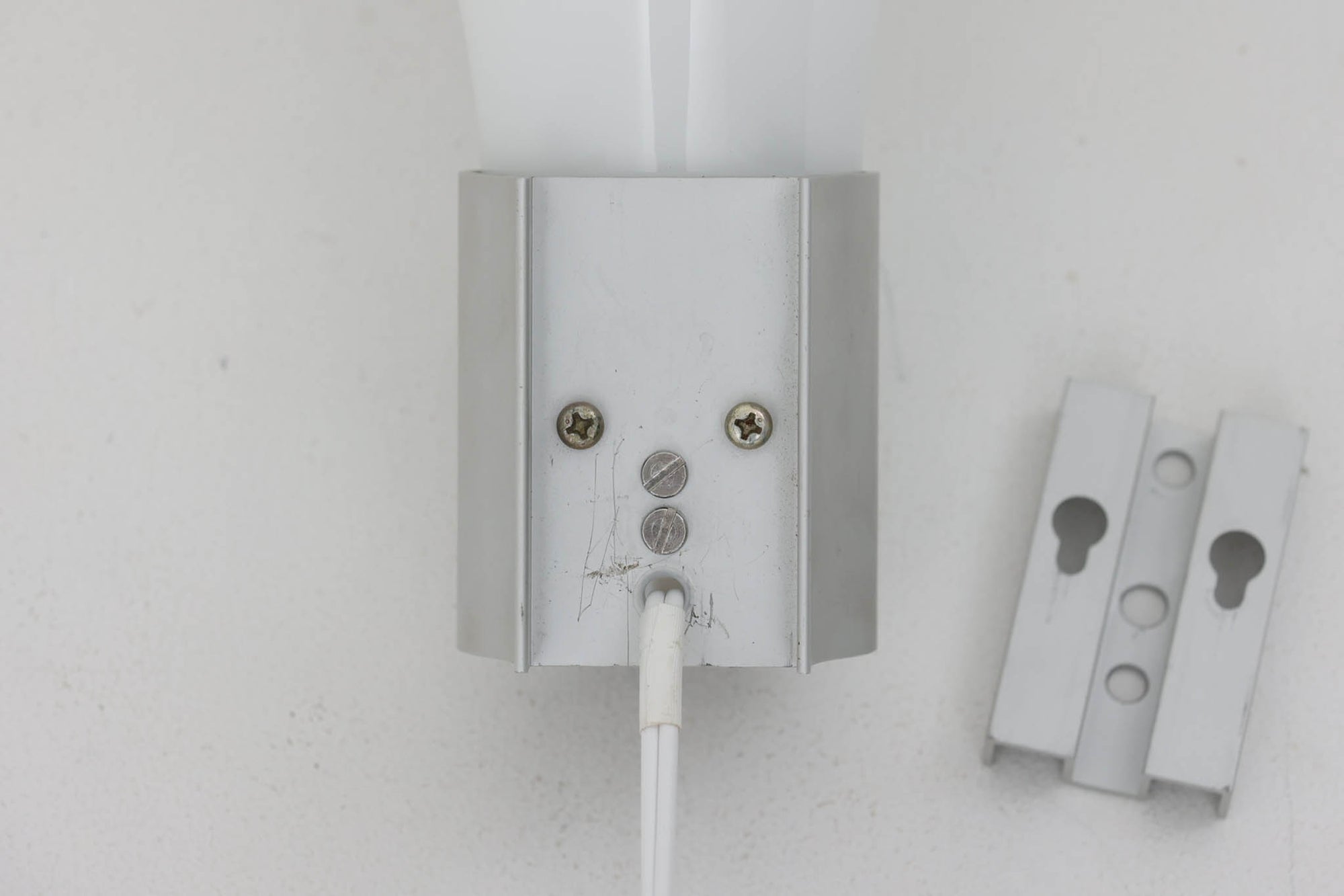 北欧より買い付けました。michael Bangを代表する「mandarin」の中で珍しい壁掛けタイプです。2展開のサイズ展開があった様ですが、こちらは大きいサイズの物。乳白色ガラスならではの優しい光が魅力的です。本製品には、取り付け部の下側にカバーがあるタイプとないタイプがありますが、こちらはアルミ部分に穴が開いており、そこをコードが通るデザインで、アルミにカバーがないタイプです。