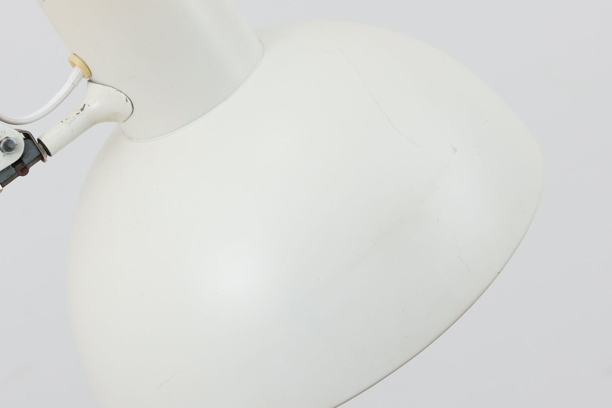 デンマークより買い付けたLouis Poulsen社製のデスクランプです。現行品では販売されていない希少なモデルで、シンプルながら機能的なデザインが特徴です。クランプタイプのため、置く場所を選ばず使用可能。最大板厚5cmまでの場所に取り付けることができるため、デスクやテーブルにしっかり固定してお使いいただけます。アーム部分は可動式で、光の角度を自由に調整できる設計になっており、デスクワークや読書、細かい作業にも最適です。ビンテージ品ならではの風合いが魅力的で、使い込まれたスチールの質感が独特の味わいを醸し出しています。