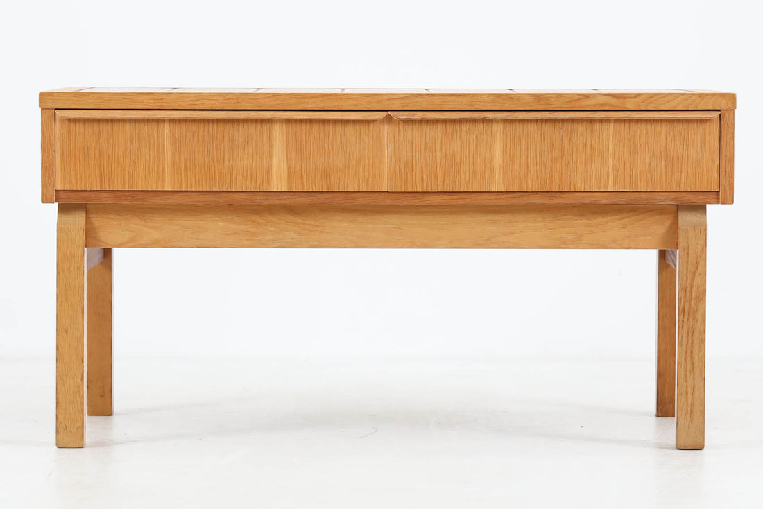 こちらは、北欧より買い付けたワイドチェストです。優れた品質のオーク材を本体に使用し、天板には淡いオレンジ色のタイルが施されており、デザインのアクセントとなっています。また、左右に取り付けられた細身の脚が、全体に洗練された印象を与えています。幅90cmのワイドサイズなので、ローボードやセンターテーブルとしてもお使いいただけます。