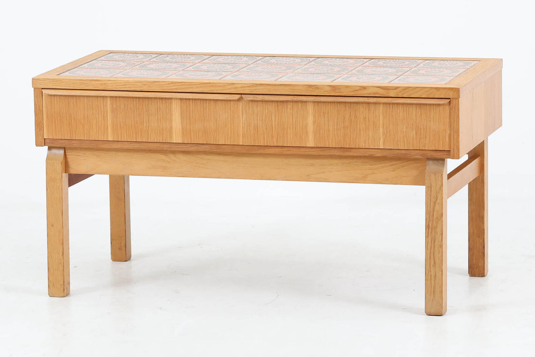 こちらは、北欧より買い付けたワイドチェストです。優れた品質のオーク材を本体に使用し、天板には淡いオレンジ色のタイルが施されており、デザインのアクセントとなっています。また、左右に取り付けられた細身の脚が、全体に洗練された印象を与えています。幅90cmのワイドサイズなので、ローボードやセンターテーブルとしてもお使いいただけます。