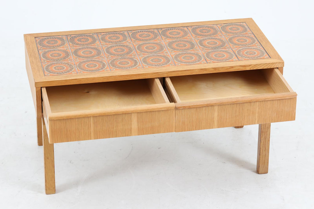 こちらは、北欧より買い付けたワイドチェストです。優れた品質のオーク材を本体に使用し、天板には淡いオレンジ色のタイルが施されており、デザインのアクセントとなっています。また、左右に取り付けられた細身の脚が、全体に洗練された印象を与えています。幅90cmのワイドサイズなので、ローボードやセンターテーブルとしてもお使いいただけます。